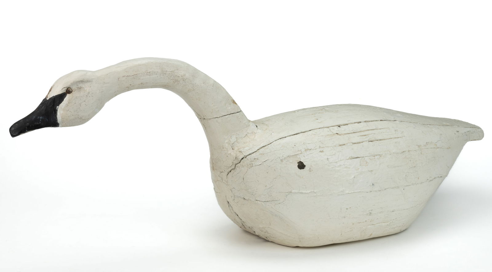 AMERICAN FOLK ART CARVED AND PAINTED SWAN DECOY: AMERICAN FOLK ART CARVED AND PAINTED SWAN DECOY, stylized solid-body from in swimming posture, retaining old working surface. First half 20th century. 15" HOA, 42" LOA.