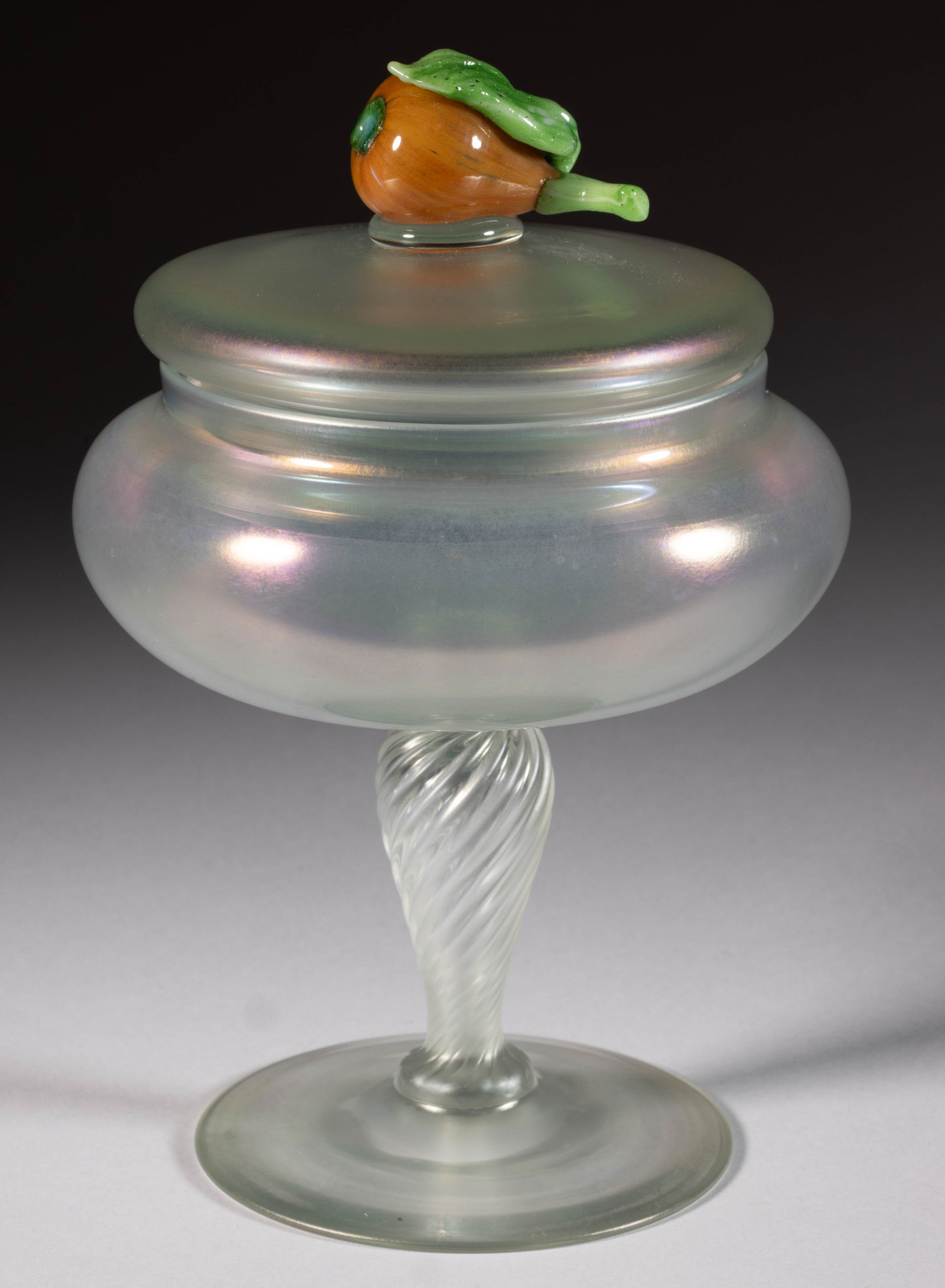 STEUBEN VERRE DE SOIE WITH FIGURAL PEAR IRIDESCENT ART GLASS COVERED VASE: STEUBEN VERRE DE SOIE WITH FIGURAL PEAR IRIDESCENT ART GLASS COVERED VASE, shape 5128, applied mottled orange figural pear finial/handle with applied green stem and leaf, twisted stem, no signature lo