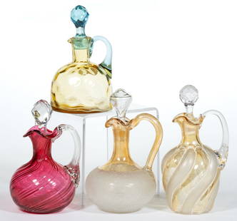 ASSORTED VICTORIAN ART GLASS CRUETS, LOT OF FOUR: ASSORTED VICTORIAN ART GLASS CRUETS, LOT OF FOUR, comprising an amber Spot-Optic dome form example with applied blue handle and cut-faceted stopper, a swirled cranberry example with applied colorless