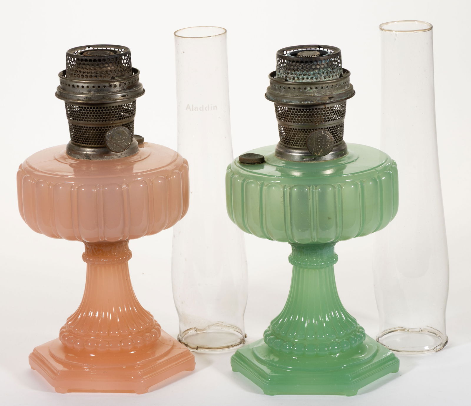 ALADDIN MODEL 111 AND 112 / CATHEDRAL KEROSENE STAND LAMPS, LOT OF TWO: ALADDIN MODEL 111 AND 112 / CATHEDRAL KEROSENE STAND LAMPS, LOT OF TWO, Pastel Green Moonstone, Pastel Flesh Moonstone, each with a hexagonal-form foot with underside having six oblong toes, side-refi