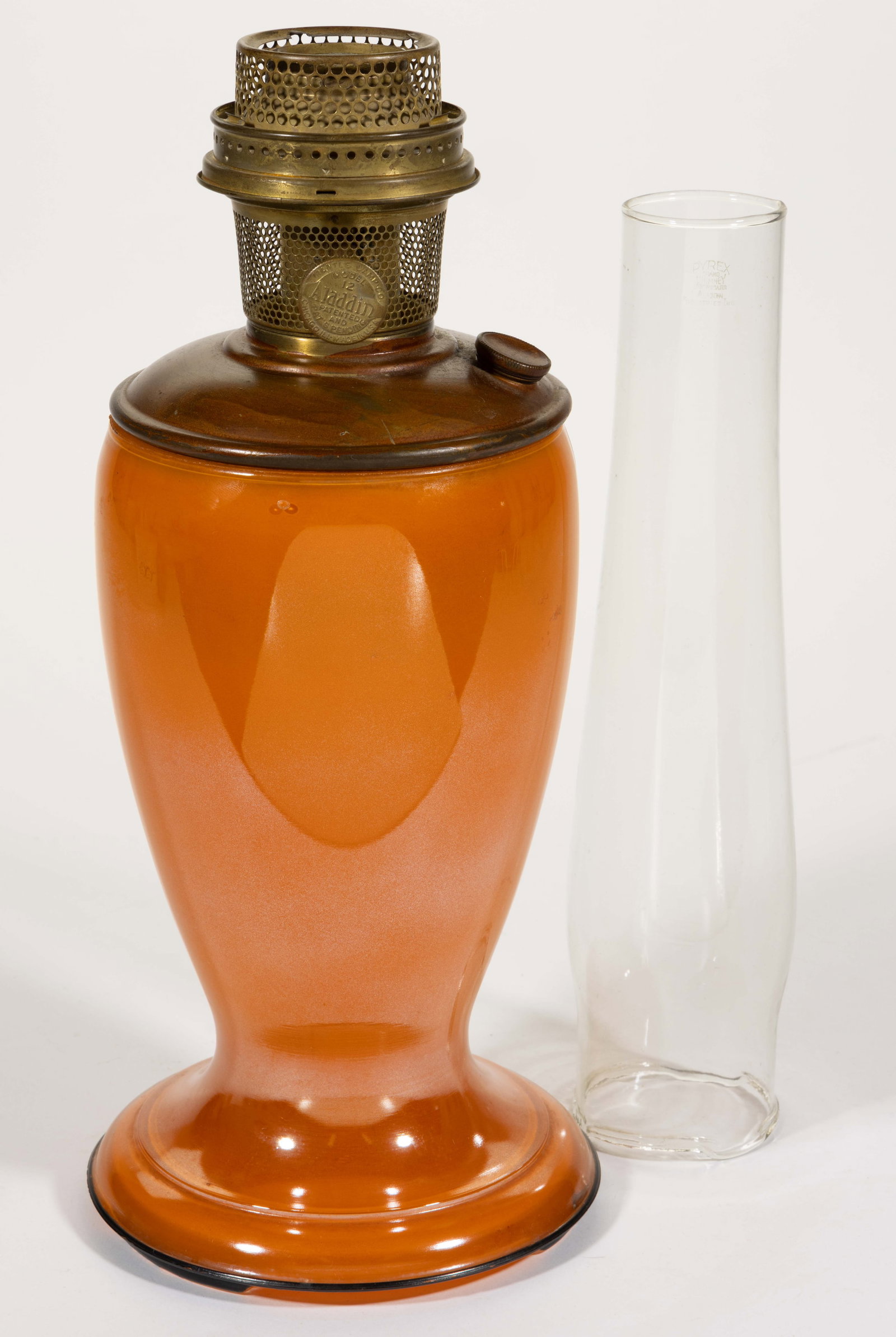 ALADDIN MODEL NO. 1246 VENETIAN ART-CRAFT KEROSENE SHORT VASE LAMP: ALADDIN MODEL NO. 1246 VENETIAN ART-CRAFT KEROSENE SHORT VASE LAMP, colorless glass vase with orange color fused on the interior, black tracing to the edge of the foot and underside having three feet.