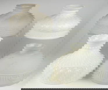 ASSORTED ALADDIN - STYLE KEROSENE LAMP SHADES, LOT OF FOUR: ASSORTED ALADDIN - STYLE KEROSENE LAMP SHADES, LOT OF FOUR, opaque white and colorless with frosted finish, comprising of a Coleman-style with panels over a stylized-floral apron, 10" D fitter; a pane