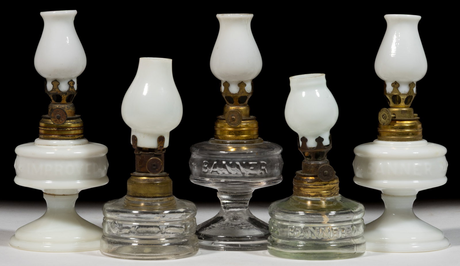 ASSORTED BANNER EMBOSSED MINIATURE LAMPS, LOT OF FIVE: ASSORTED BANNER EMBOSSED MINIATURE LAMPS, LOT OF FIVE, colorless and opaque white, comprising o, three examples embossed "IMPROVED BANNER"/Smith I, fig. 20; a "LITTLE BANNER"/Smith II, fig. 49 and rem