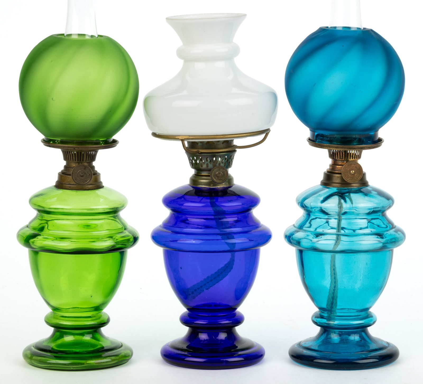 ASSORTED COLORED GLASS MINIATURE LAMPS, LOT OF THREE: ASSORTED COLORED GLASS MINIATURE LAMPS, LOT OF THREE, green, cobalt blue, and peacock blue, comprising of two with a panel-optic pattern and a swirl-optic ball-form shade with satin finish; remaining 