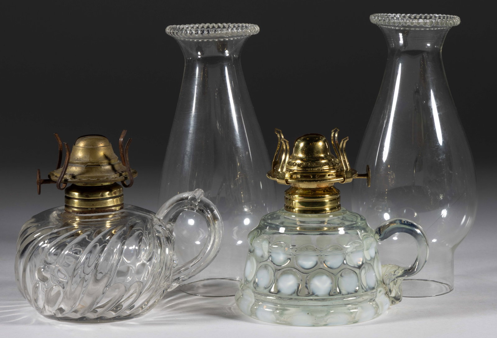 ASSORTED PATTERNED FINGER LAMPS, LOT OF TWO: ASSORTED PATTERNED FINGER LAMPS, LOT OF TWO, comprising a Coinspot/Emma with applied colorless handle and a rib swirl and dot patterned example with colorless molded handle, each with a No. 1 Taplin-B