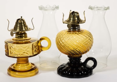 ASSORTED PATTERNED KEROSENE FOOTED FINGER LAMPS, LOT OF TWO