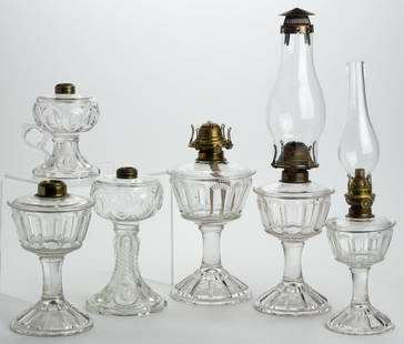 ASSORTED PATTERNED KEROSENE LAMPS, LOT OF SIX: ASSORTED PATTERNED KEROSENE LAMPS, LOT OF SIX, colorless, comprising five stand examples and a footed finger example; patterns include two Bullseye with Diamond Point; two Duncan Bar -Rayed Panel; and
