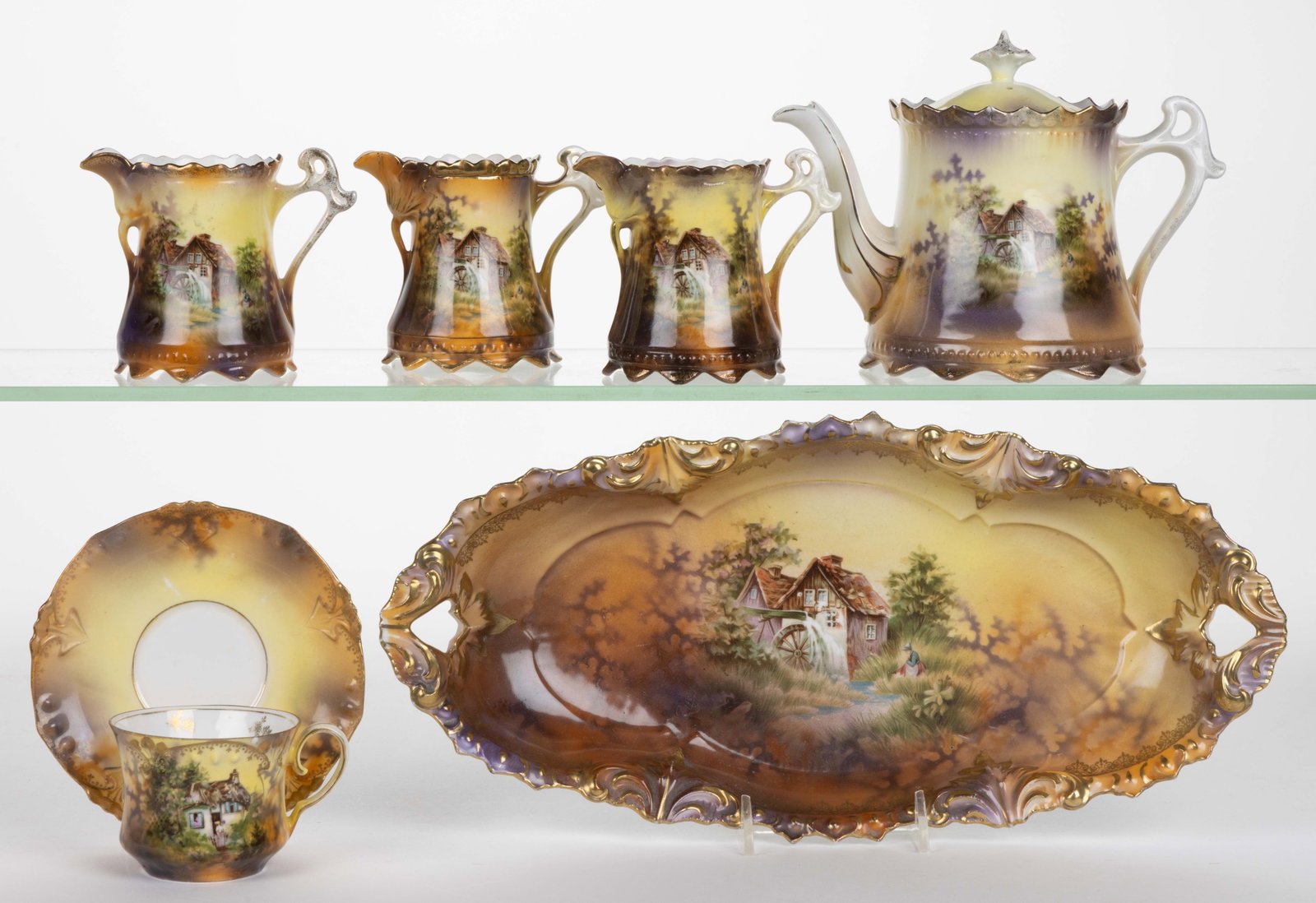 R.S. PRUSSIA PORCELAIN SCENIC MOTIF TEA AND TABLE ARTICLES, LOT OF SIX: R.S. PRUSSIA PORCELAIN SCENIC MOTIF TEA AND TABLE ARTICLES, LOT OF SIX, each having polychrome transfer scenes on yellow ground with purple shadow trees, comprising one cup and saucer set featuring a 