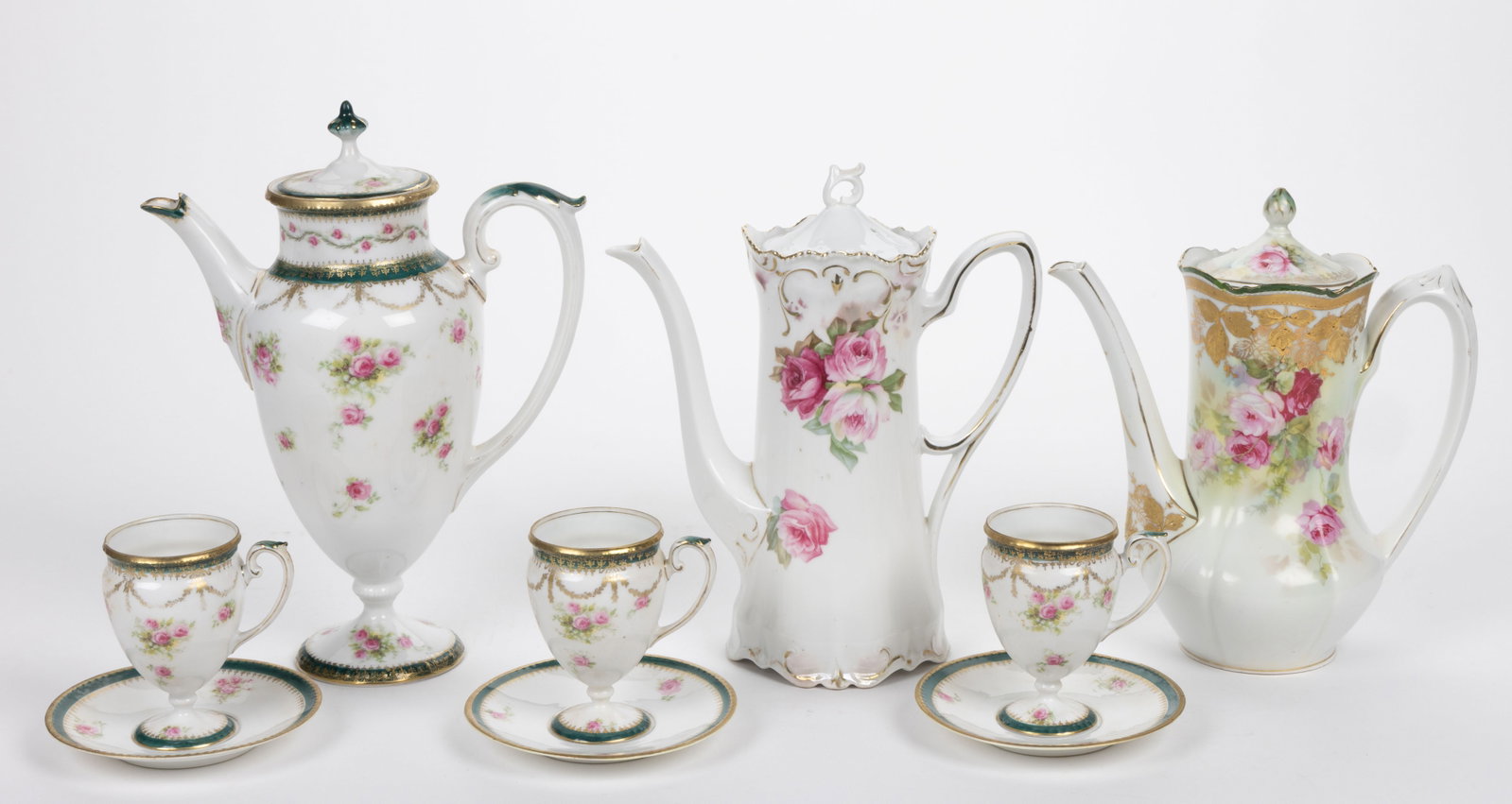 R.S. PRUSSIA PORCELAIN FLORAL MOTIF COFFEE ARTICLES, LOT OF NINE: R.S. PRUSSIA PORCELAIN FLORAL MOTIF COFFEE ARTICLES, LOT OF NINE, each having polychrome transfer rose designs, comprising a four-piece pedestalled set consisting of a coffee pot and three cup and sau