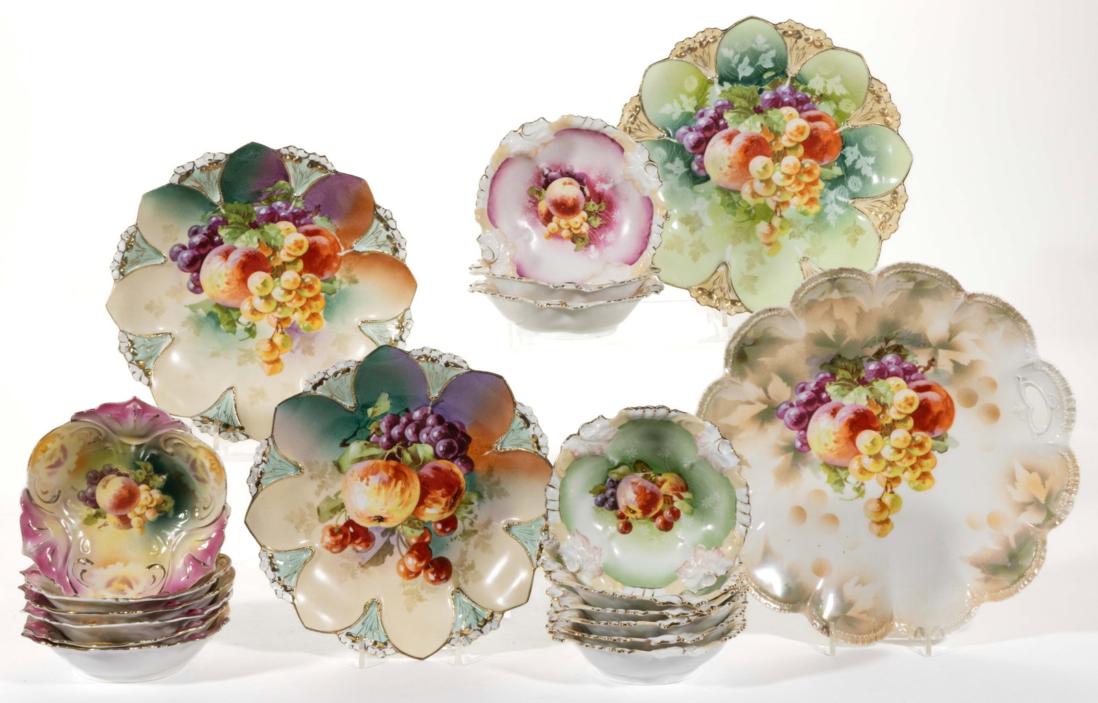 R.S. PRUSSIA PORCELAIN FRUIT MOTIF TABLE ARTICLES, LOT OF 19: R.S. PRUSSIA PORCELAIN FRUIT MOTIF TABLE ARTICLES, LOT OF 19, comprising one open-handled cake plate with lustre finish, three 8 3/4" D Mold 90 shallow dishes with double daisy flower rim decorations,