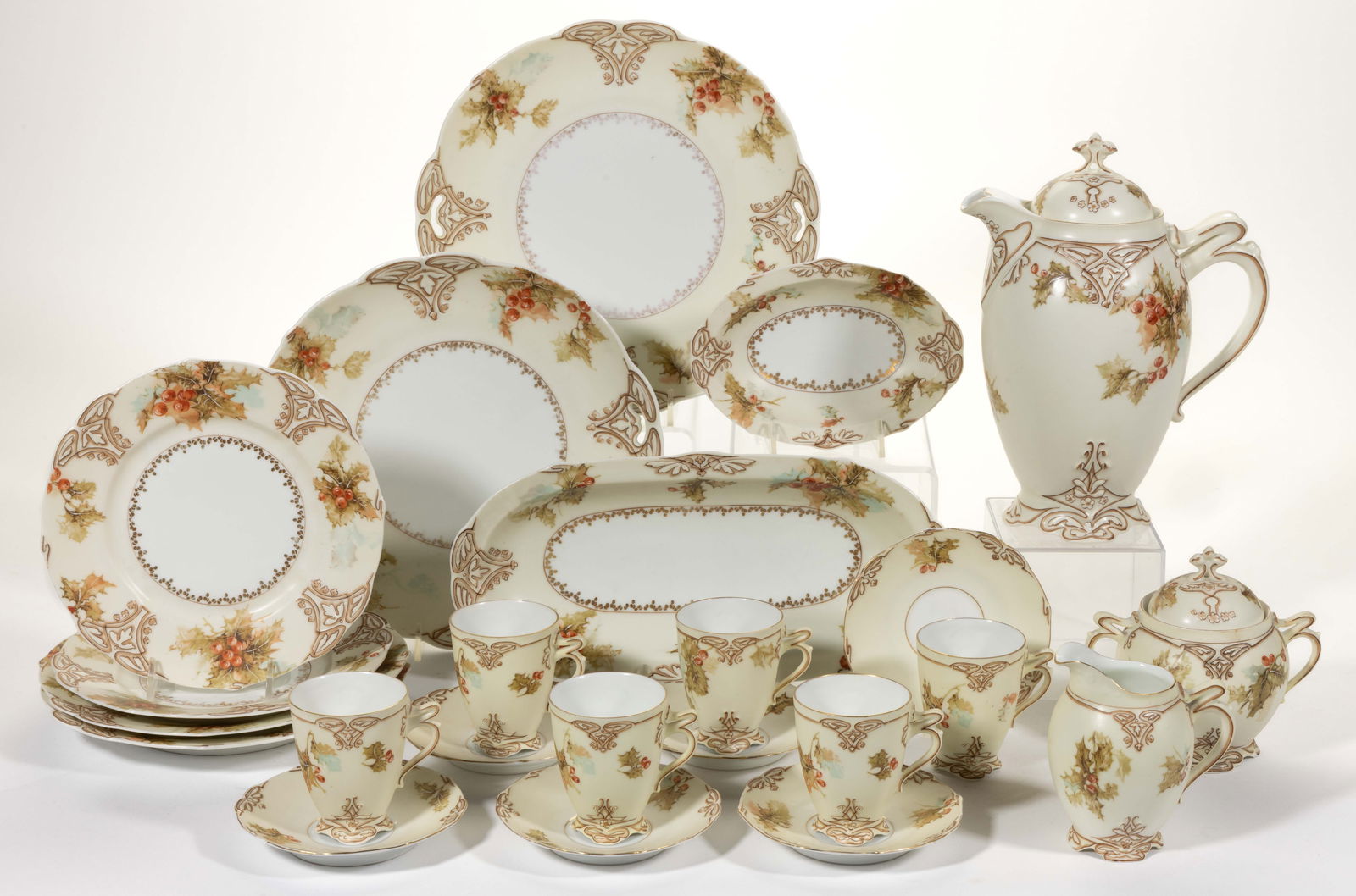 GERMAN PORCELAIN OLD IVORY XXII HOLLY MOTIF ASSORTED ARTICLES, LOT OF 17: GERMAN PORCELAIN OLD IVORY XXII HOLLY MOTIF ASSORTED ARTICLES, LOT OF 17, each having a white center with gilt transfer decoration and cream border featuring green holly with red berries, comprising a