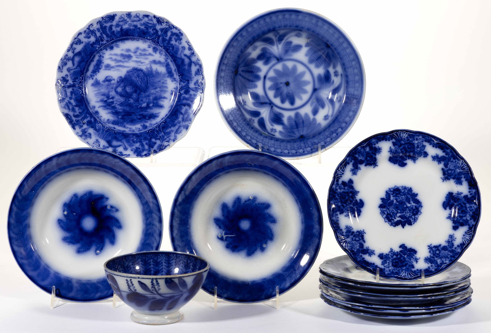 BRITISH AND DUTCH FLOW BLUE IRONSTONE TABLE ARTICLES, LOT OF 13: BRITISH AND DUTCH FLOW BLUE IRONSTONE TABLE ARTICLES, LOT OF 13, including two matching soup plates with sun-like design to center, two Societe Ceramique Maestricht examples including a bowl and a sou