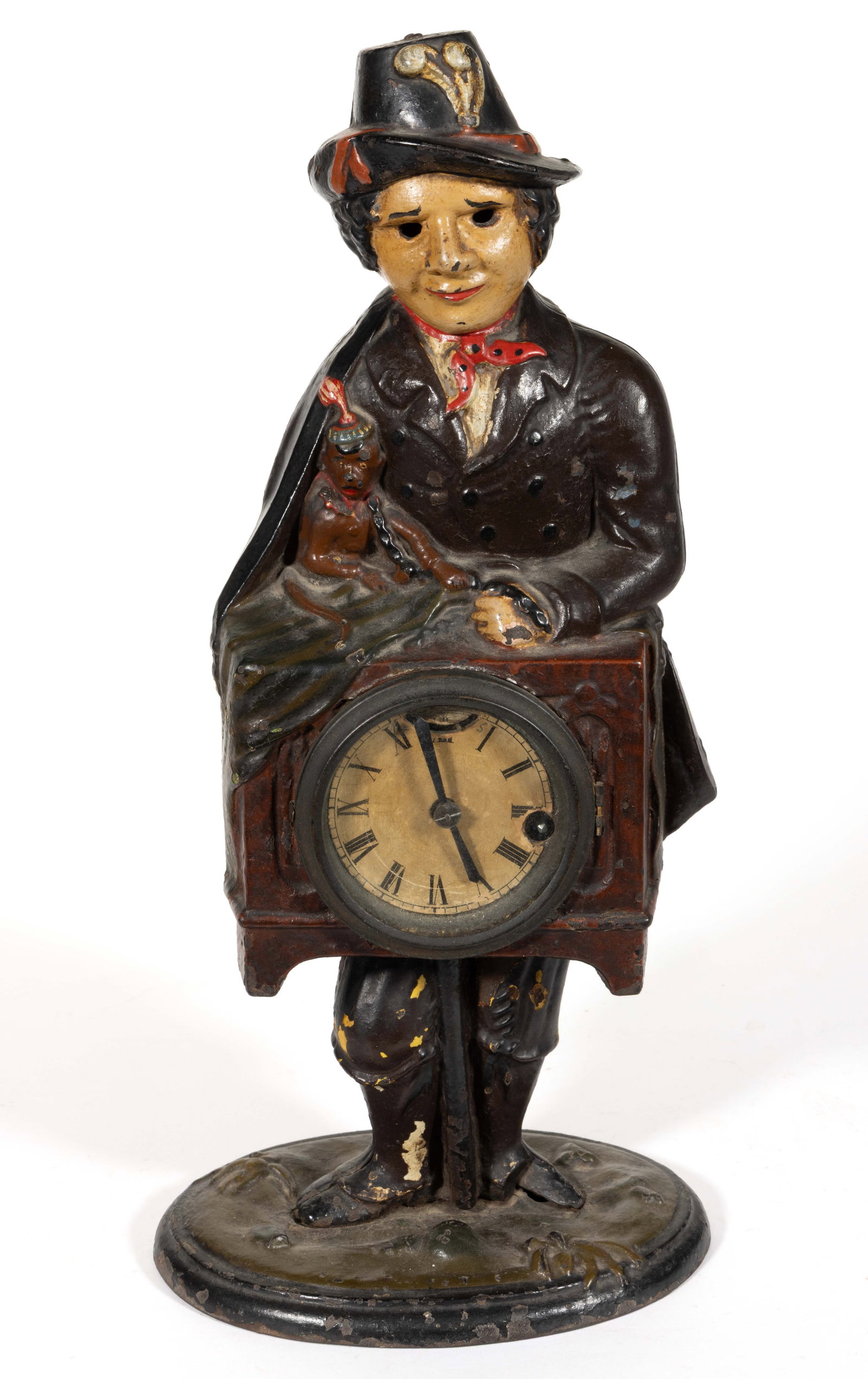 BRADLEY & HUBBARD FIGURAL CAST-IRON ORGAN GRINDER BLINKING EYE CLOCK: BRADLEY & HUBBARD FIGURAL CAST-IRON ORGAN GRINDER BLINKING EYE CLOCK, cast in two halves and joined to an oval base with naturalistic motif, depicting an organ grinder standing with his trained mo