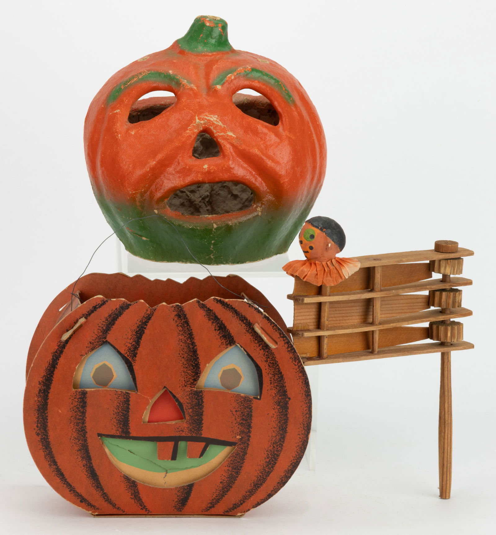 ASSORTED GERMAN AND AMERICAN HALLOWEEN ARTICLES, LOT OF THREE: ASSORTED GERMAN AND AMERICAN HALLOWEEN ARTICLES, LOT OF THREE, comprising a pulp / papier-mache jack-o-lantern with a covered top and stem; a Dolly Toy Co. cardboard jack-o-lantern with two faces, one