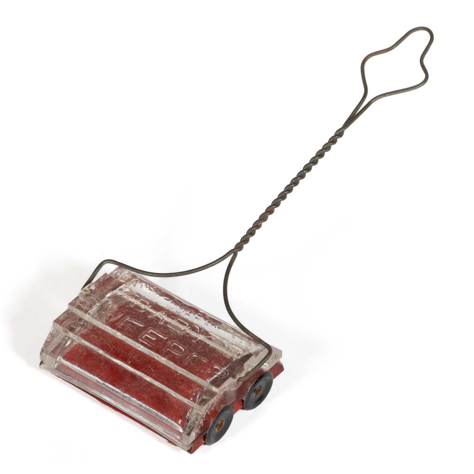 BABY SWEEPER / CARPET SWEEPER FIGURAL PRESSED GLASS CANDY CONTAINER: BABY SWEEPER / CARPET SWEEPER FIGURAL PRESSED GLASS CANDY CONTAINER, colorless, pressed in the form of a round-topped rectangular-box carpet sweeper, embossed "CANDY GUARANTEED / BABY / SWEEPER /