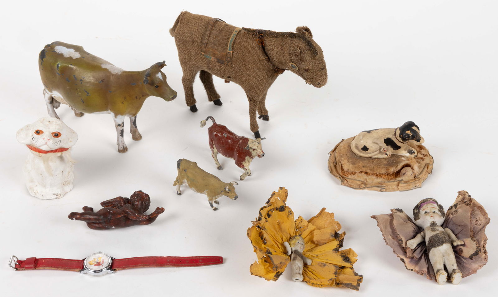 ASSORTED ANTIQUE AND VINTAGE CHILDREN'S TOYS, LOT OF TEN: ASSORTED ANTIQUE AND VINTAGE CHILDREN'S TOYS, LOT OF TEN, including three metal cows, one marked for Britains, and two Japanese bisque dolls with crepe paper outfits/wings. 20th century. 6&qu