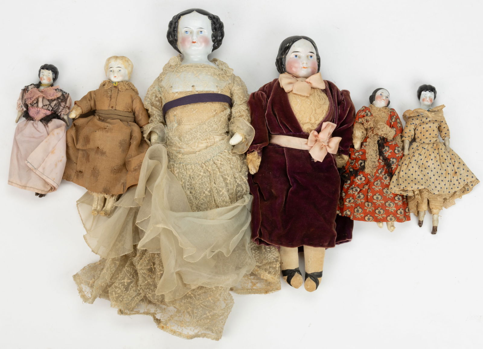 ASSORTED CHINA AND BISQUE HEAD DOLLS, LOT OF SIX: ASSORTED CHINA AND BISQUE HEAD DOLLS, LOT OF SIX, comprising of five china head examples, each with black painted and molded hair including covered-wagon styles, one example with shoulder plate impres