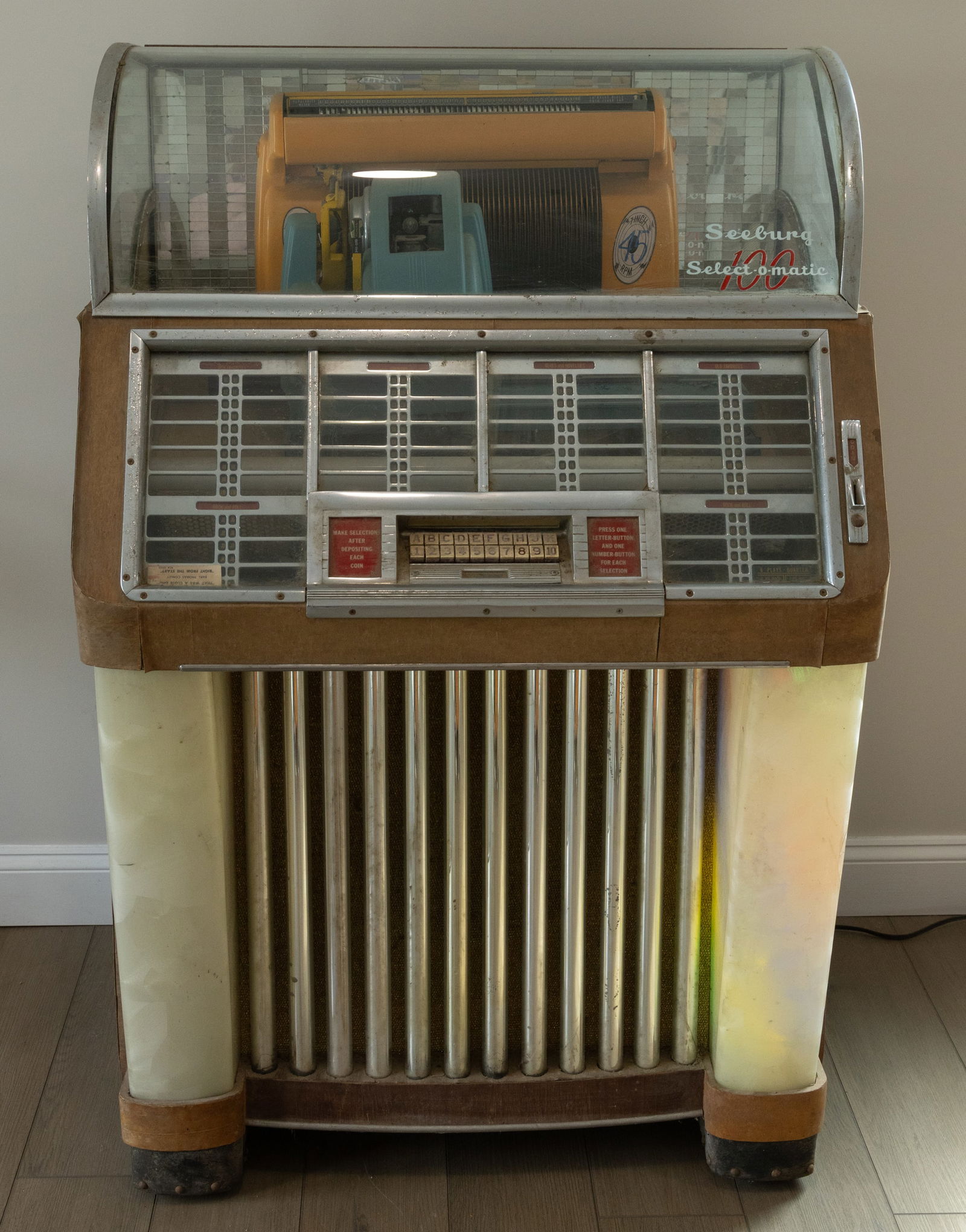 ORIGINAL SEEBURG SELECT-O-MATIC 100 JUKEBOX: ORIGINAL SEEBURG SELECT-O-MATIC 100 JUKEBOX, retaining a full tray of 45 rpm records. Circa 1960. 54" HOA, 35 1/2" WOA, 26" D.