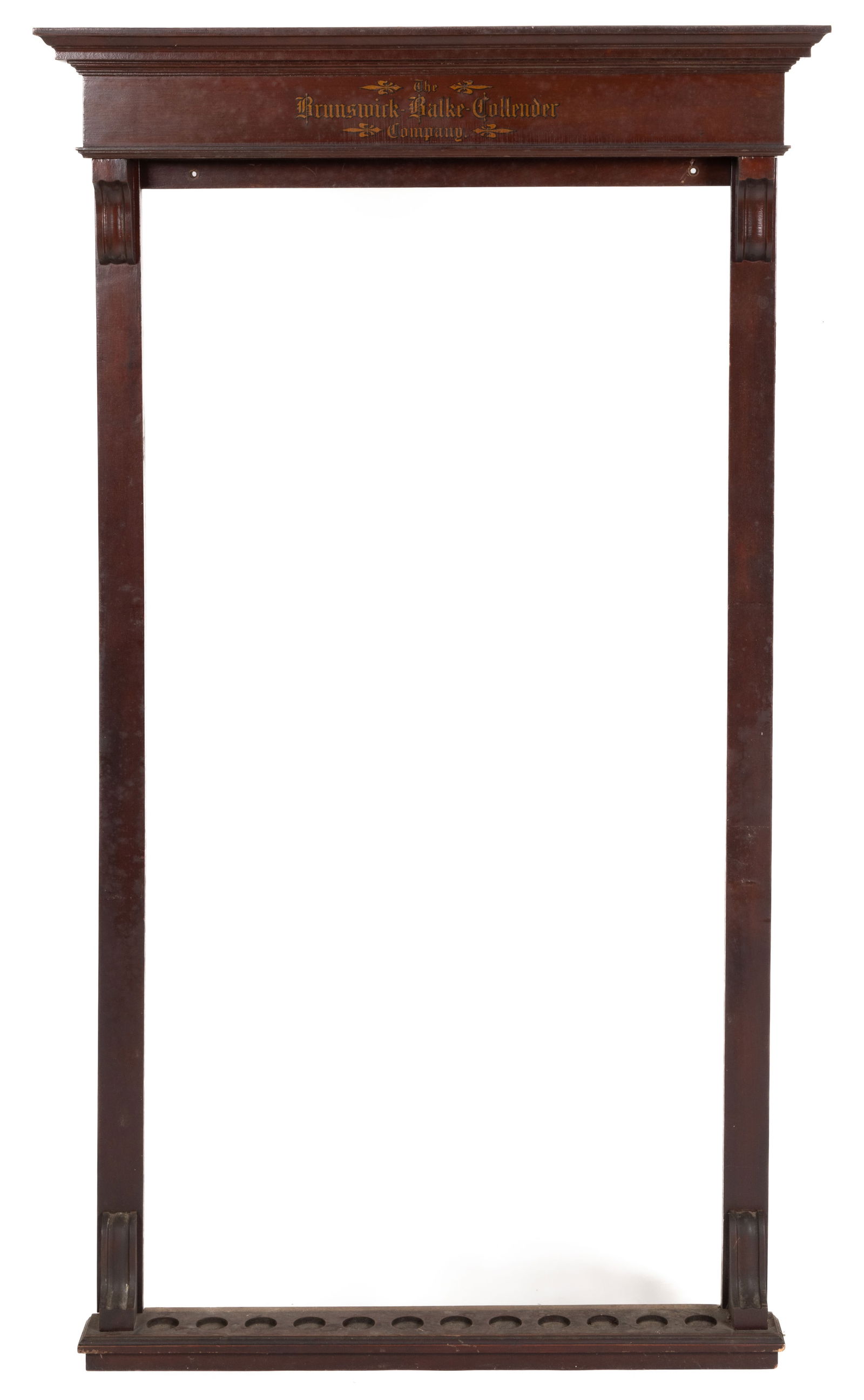 BRUNSWICK-BALKE-COLLENDER COMPANY WALNUT BILLIARD'S CUE RACK: BRUNSWICK-BALKE-COLLENDER COMPANY WALNUT BILLIARD'S CUE RACK, the molded cornice with a transfer of the company name in the frieze over a base with spaces for 12 cues which correspond to 12 holes