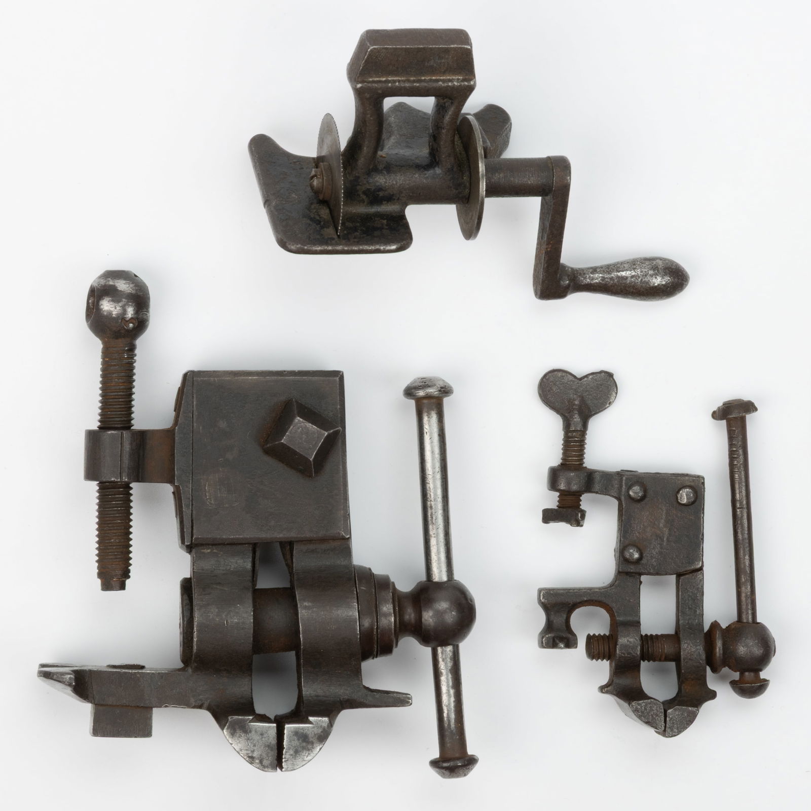 ASSORTED IRON JEWELERS / WATCHMAKER / GUNSMITH TABLE-TOP VISES AND ACCESSORIES, LOT OF THREE: ASSORTED IRON JEWELERS / WATCHMAKER GUNSMITH TABLE-TOP VISES AND ACCESSORIES, LOT OF THREE, comprising of a bench example possibly a John Wyke No. 303 example (Liverpool, 1759-1787), one sid