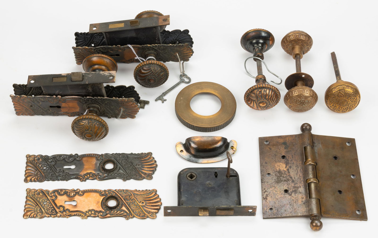 ASSORTED METAL DOOR AND CABINETRY HARDWARE, UNCOUNTED LOT: ASSORTED METAL DOOR AND CABINETRY HARDWARE, UNCOUNTED LOT, comprising of brass examples with stamped ornamentation in scrolls and floral patterns, including three locks with handles sets, ea
