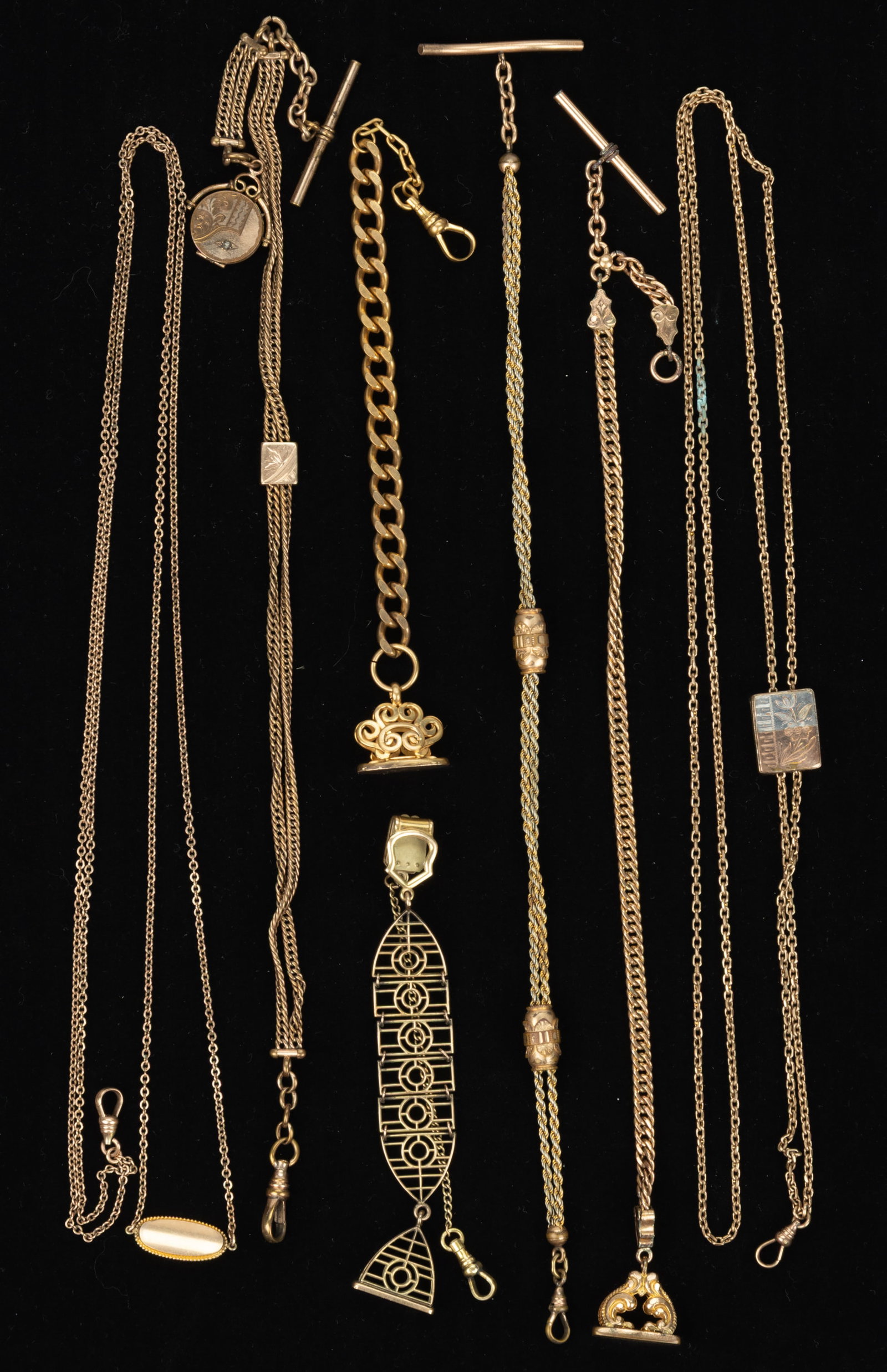 ANTIQUE / VINTAGE GOLD-FILLED / GOLD-PLATED WATCH CHAINS, LOT OF SEVEN: ANTIQUE / VINTAGE GOLD-FILLED / GOLD-PLATED WATCH CHAINS, LOT OF SEVEN, comprising a watch chain with a clip fastener and an attached Art Deco chain and wax seal-form fob with engraved "C.W.L.&qu