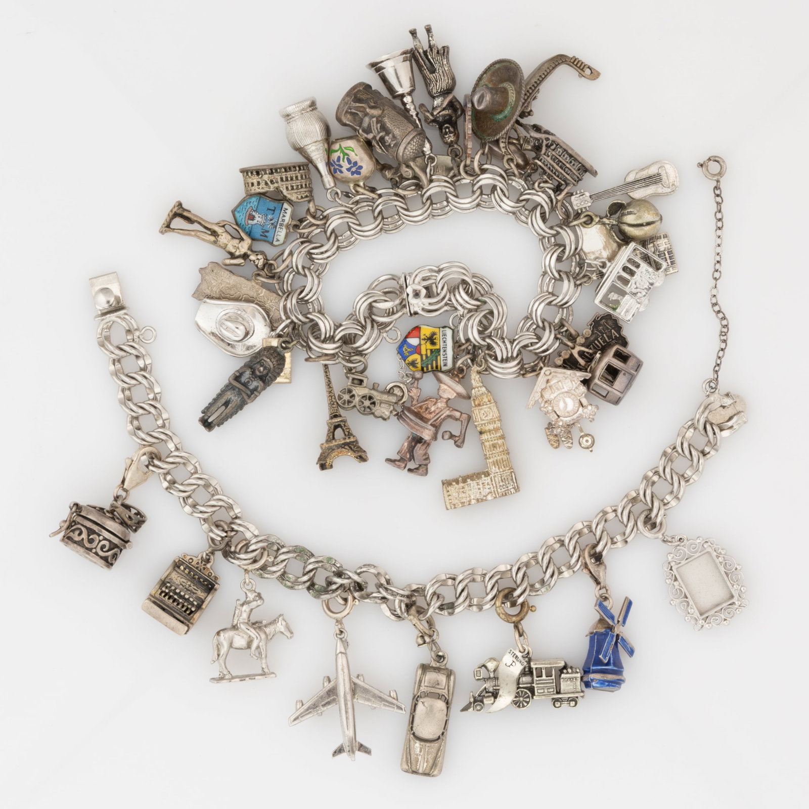 VINTAGE / CONTEMPORARY STERLING SILVER AND OTHER CHARM BRACELETS, LOT OF TWO: VINTAGE / CONTEMPORARY STERLING SILVER AND OTHER CHARM BRACELETS, LOT OF TWO, each bracelet marked for sterling though magnetic having hidden tab-insert box clasp and safety chain; comprising one