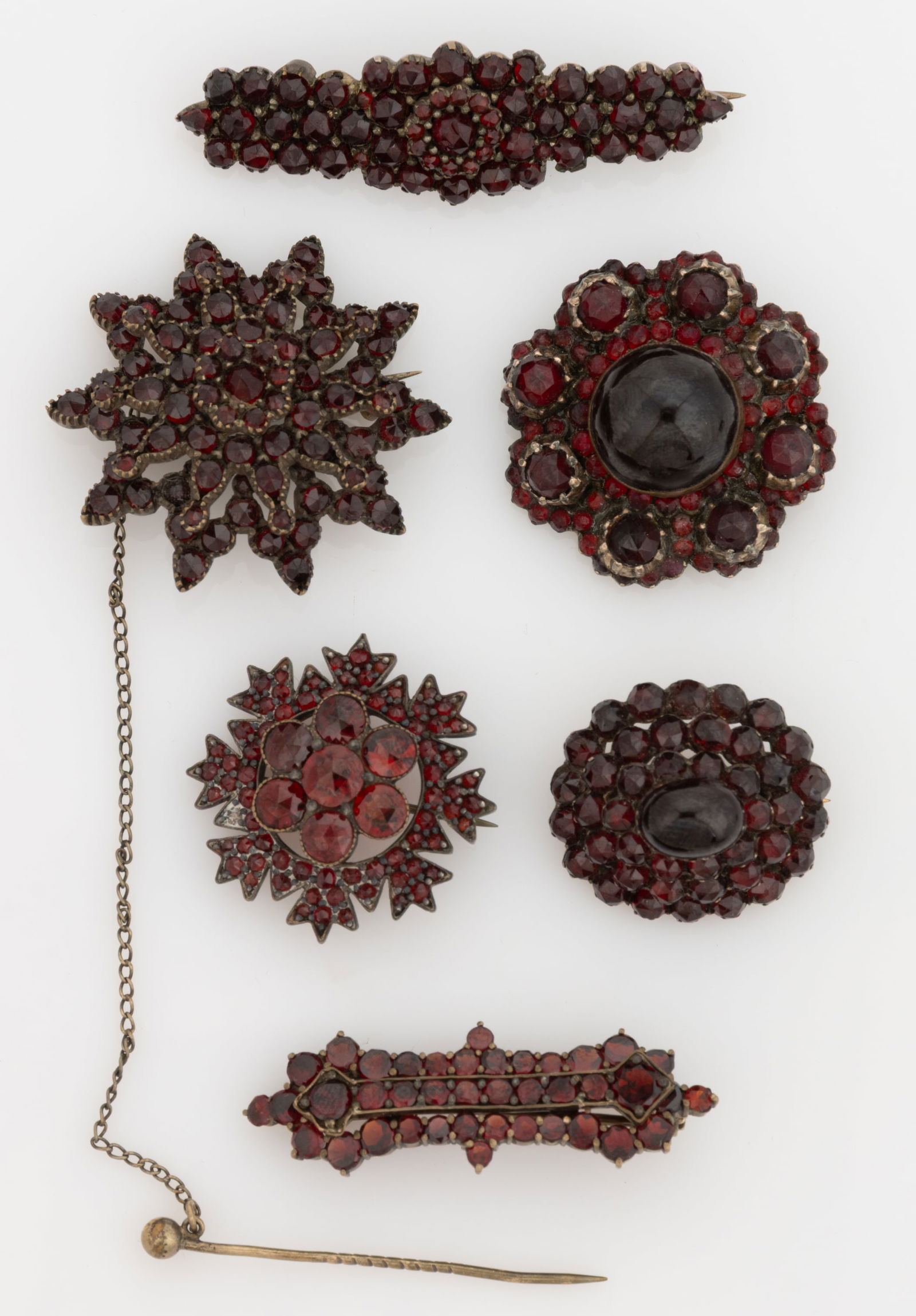 VICTORIAN / ANTIQUE GOLD-FILLED AND OTHER GARNET BROOCHES / PINS, LOT OF SIX: VICTORIAN / ANTIQUE GOLD-FILLED AND OTHER GARNET BROOCHES / PINS, LOT OF SIX, each piece set with multiple cut garnet stones, comprising a star form with an attached safety pin, one with a seven-clust