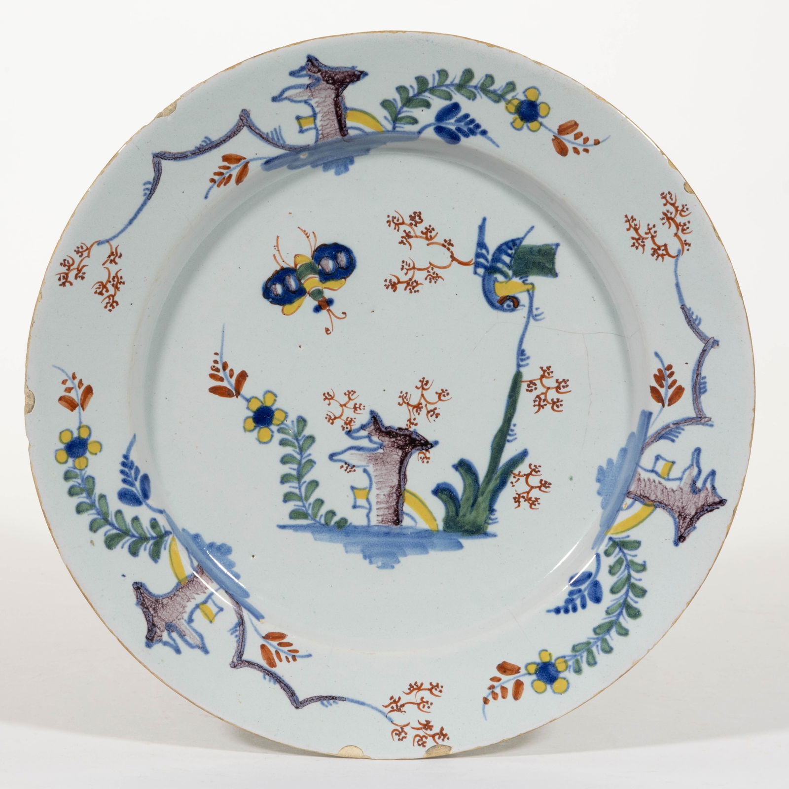 ENGLISH DELFT TIN-GLAZED HAND-PAINTED EARTHENWARE PLATE: ENGLISH DELFT TIN-GLAZED HAND-PAINTED EARTHENWARE PLATE, featuring polychrome scene depicting a bird and large insect above stylized plants and rock. Unmarked. 18th century. 8 3/4" D. P