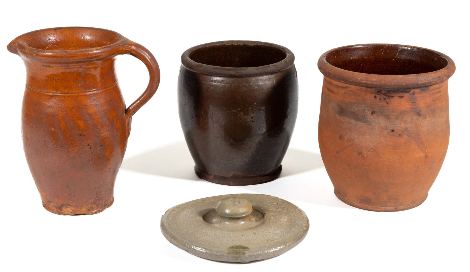 AMERICAN EARTHENWARE AND STONEWARE ARTICLES, LOT OF FOUR: AMERICAN EARTHENWARE AND STONEWARE ARTICLES, LOT OF FOUR, comprising and 6 1/8" D salt-glazed stoneware cover and three lead-glazed earthenware/redware examples including a pitcher with rounded r