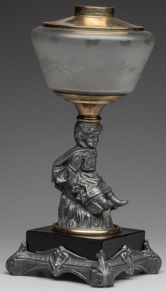 CAST-SPELTER FIGURAL STEM STAND LAMP: CAST-SPELTER FIGURAL STEM STAND LAMP colorless font with frosted finish, cut and engraved punties over floral pattern, stem depicting a little girl on a sled, metal and cast-metal base with leaf ornam