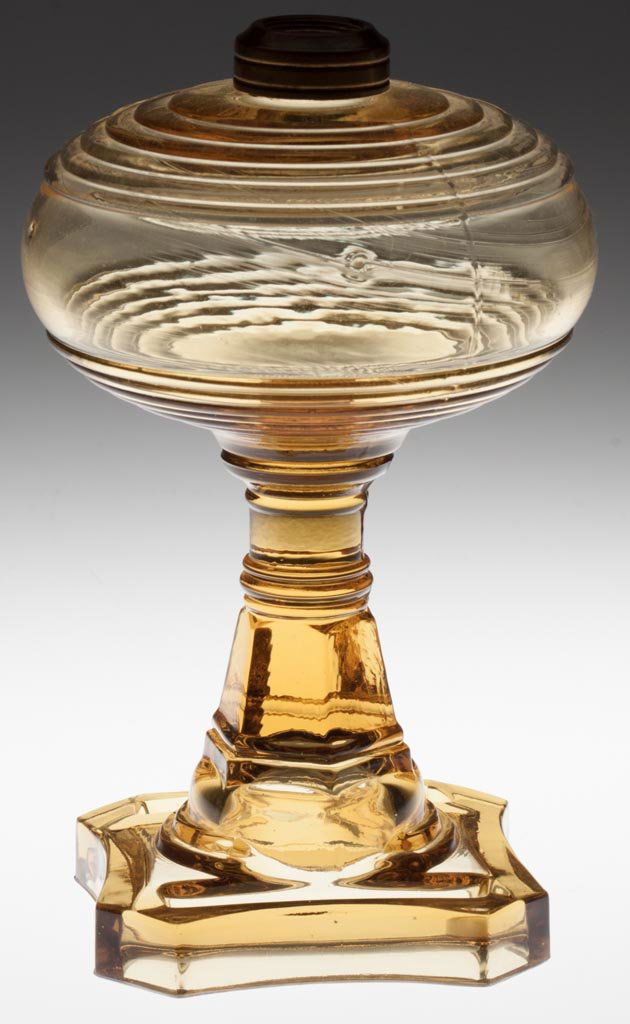 MATCH HOLDER BASE STAND LAMP: MATCH HOLDER BASE STAND LAMP honey amber, No. 1 Taplin-Brown collar. Fourth quarter 19th century. 8 1/8" H to top of collar, 4" SQ base. Literature: Parallels Thuro II, p. 117m. Provenance: From the c