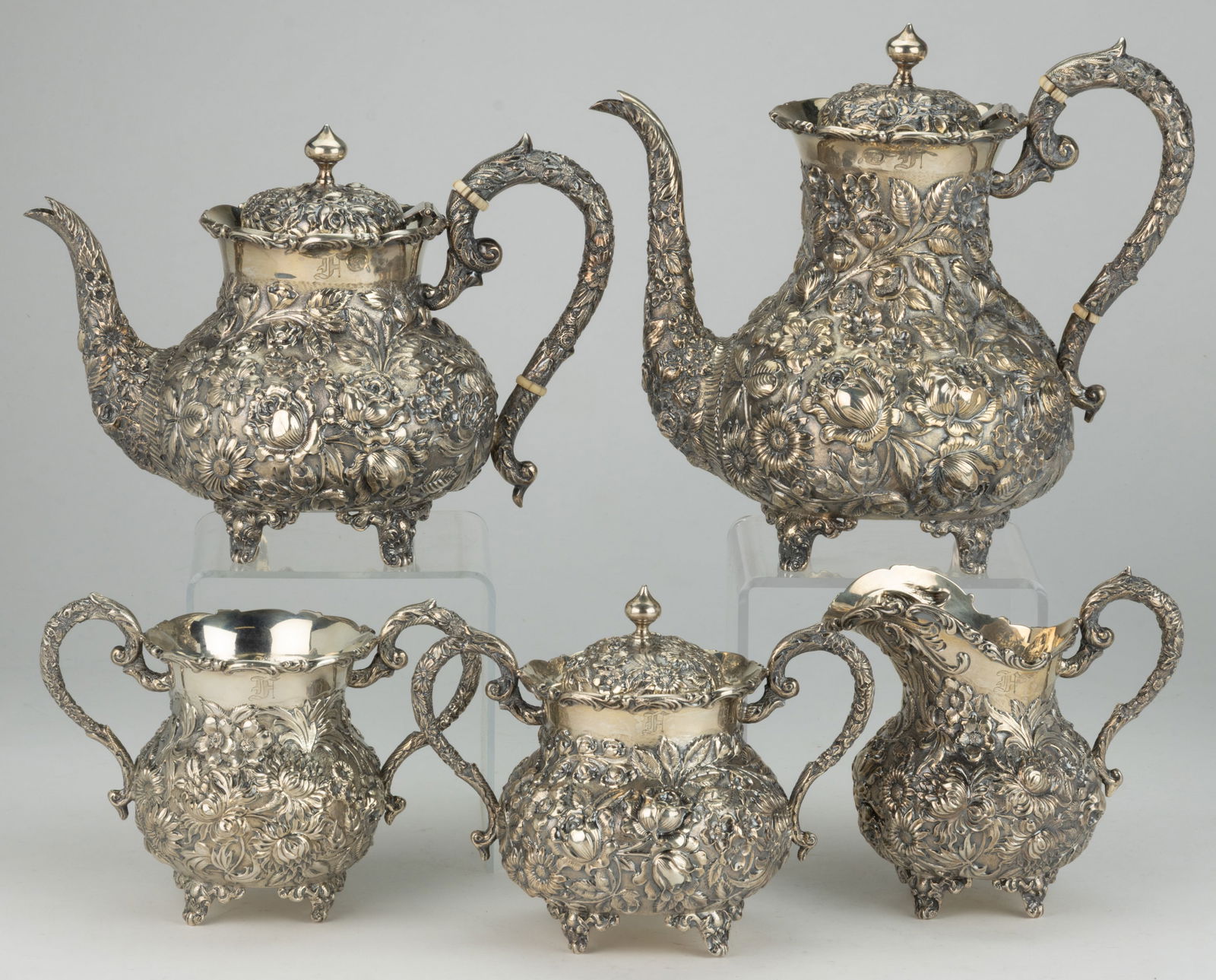 BALTIMORE, MARYLAND REPOUSSE STERLING SILVER FIVE-PIECE COFFEE AND TEA SERVICE: BALTIMORE, MARYLAND STERLING SILVER FIVE-PIECE COFFEE AND TEA SERVICE, comprising a coffee pot, a teapot, a covered sugar, a creamer, and an open sugar, or possibly waste bowl, each having ornate repo