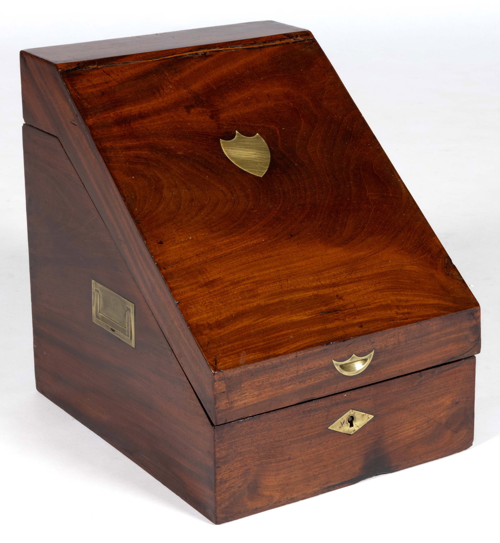 ENGLISH BRASS-INLAID MAHOGANY KNIFE BOX: ENGLISH BRASS-INLAID MAHOGANY KNIFE BOX, the hinged slant top with a central shield-form brass boss, and a matching smaller indented grip conceals an open interior with a later lining, the base of the