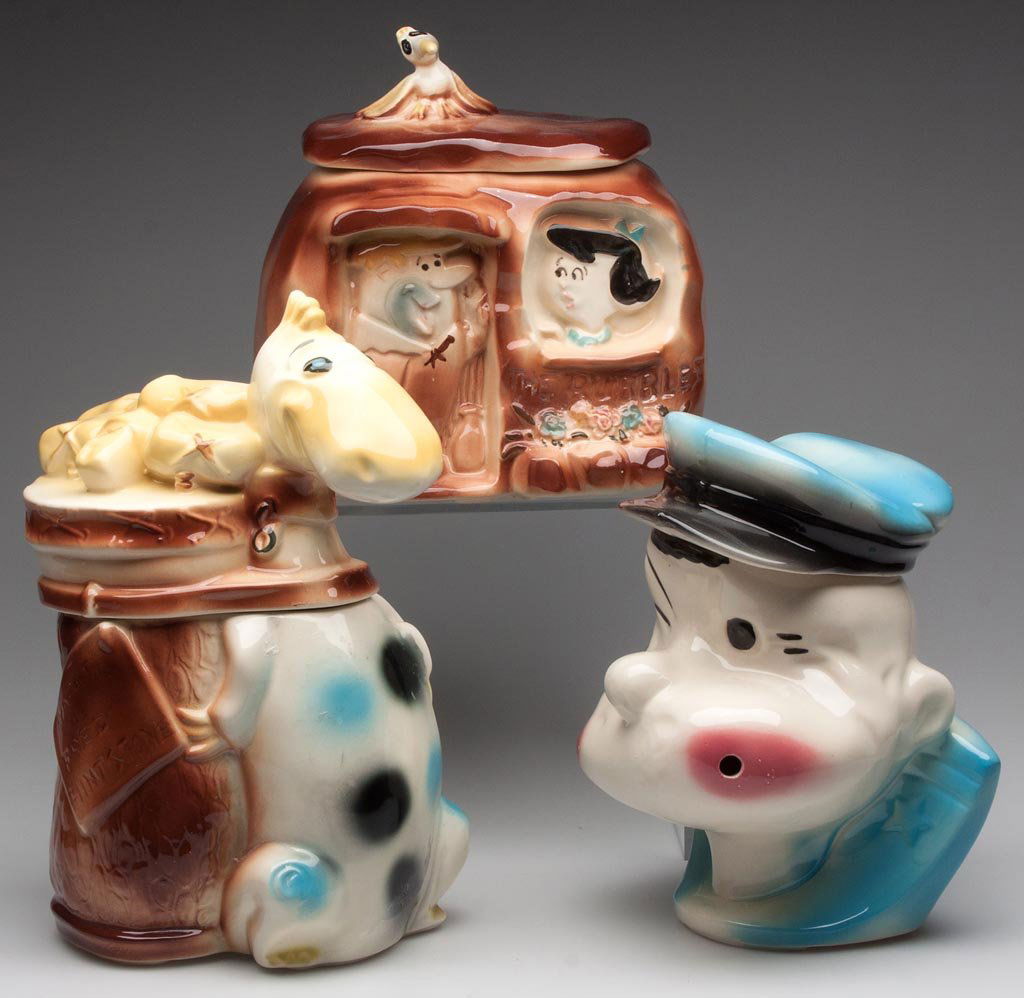 AMERICAN BISQUE POTTERY COMIC CHARACTER COOKIE JARS, LO: AMERICAN BISQUE POTTERY COMIC CHARACTER COOKIE JARS, LOT OF THREE, comprising The Flintstone's Dino caddy and "The Rubbles" house, and Popeye. Third quarter 20th century. 9 1/4" to 13" HOA. Provenance