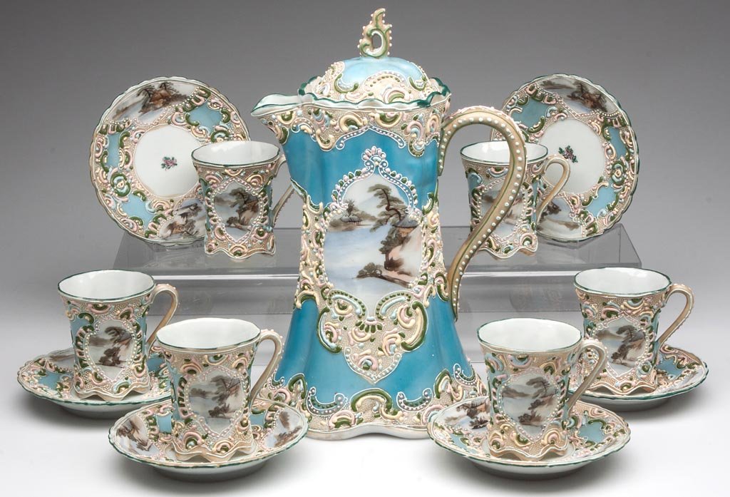 JAPANESE MORIAGE-DECORATED CHOCOLATE SET, 13 PIECES: JAPANESE MORIAGE-DECORATED CHOCOLATE SET, 13 PIECES, comprising a pot with six cups and saucers, the turquoise grounds with elaborate moriage paste in pastel colors forming cartouches around landscape
