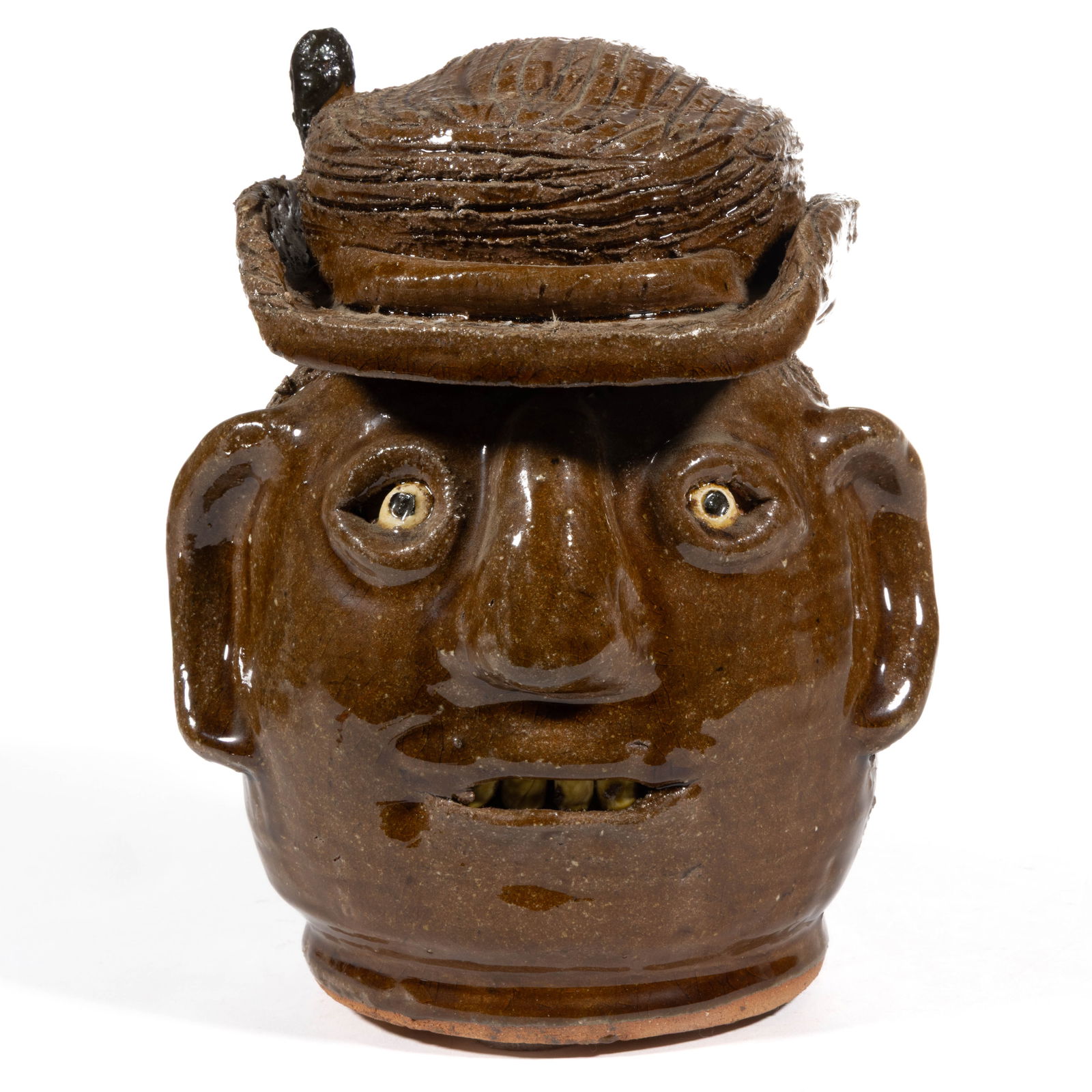 SIGNED "REGGIE MEADERS" (AMERICAN, 1919-2009), GEORGIA STONEWARE FACE JUG WITH HAT: SIGNED "REGGIE MEADERS" (AMERICAN, 1919-2009), GEORGIA STONEWARE FACE JUG WITH HAT, alkaline-glazed, hand-modeled and wearing a derby-style hat with feather, having inset ceramic eyes,