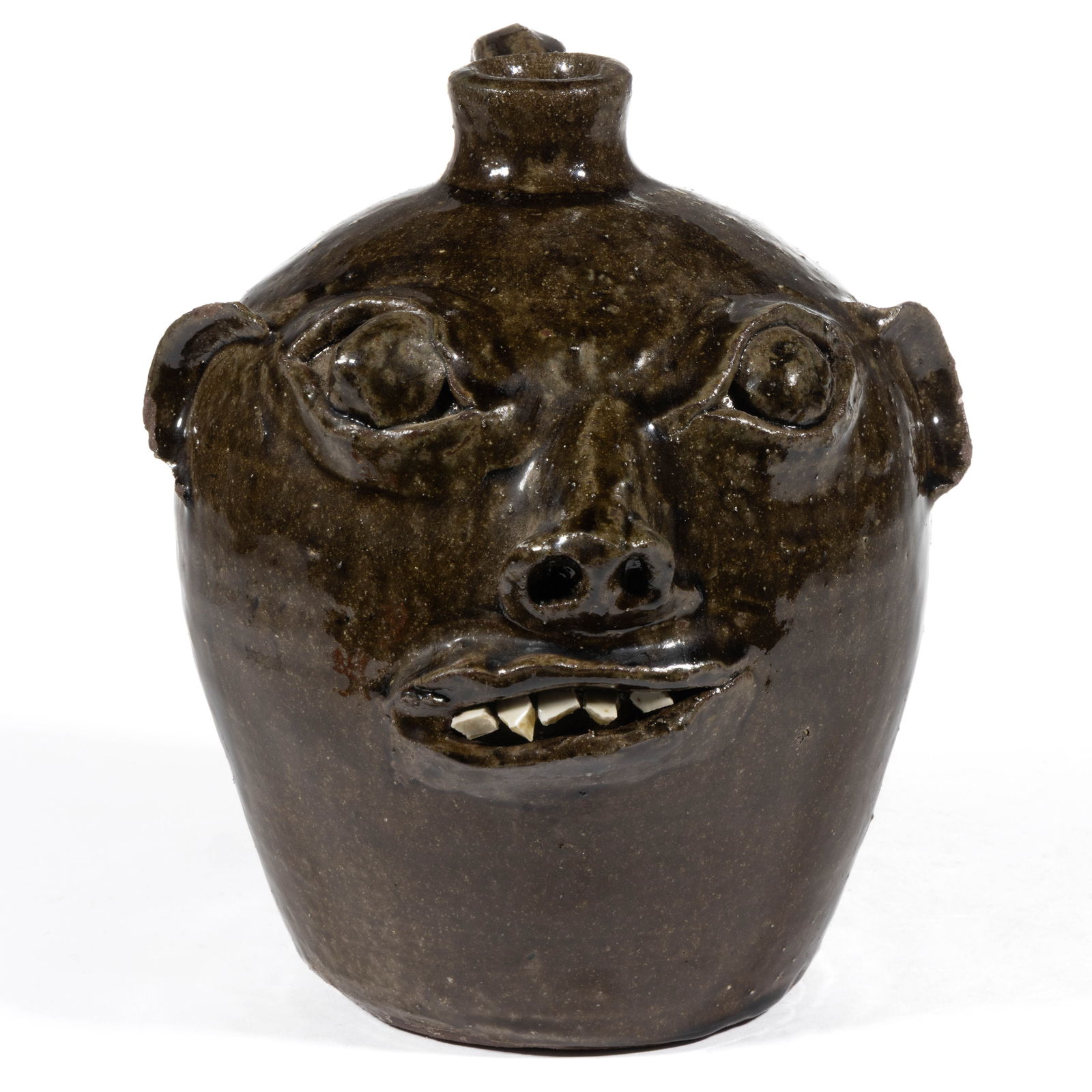 SIGNED "CHESTER HEWELL" (AMERICAN, B. 1950), GEORGIA STONEWARE FACE JUG: SIGNED "CHESTER HEWELL" (AMERICAN, B. 1950), GEORGIA STONEWARE FACE JUG, alkaline-glazed, hand-modeled having beady, protruding eyes, applied ears and nose with pierced nostrils, and lips fr