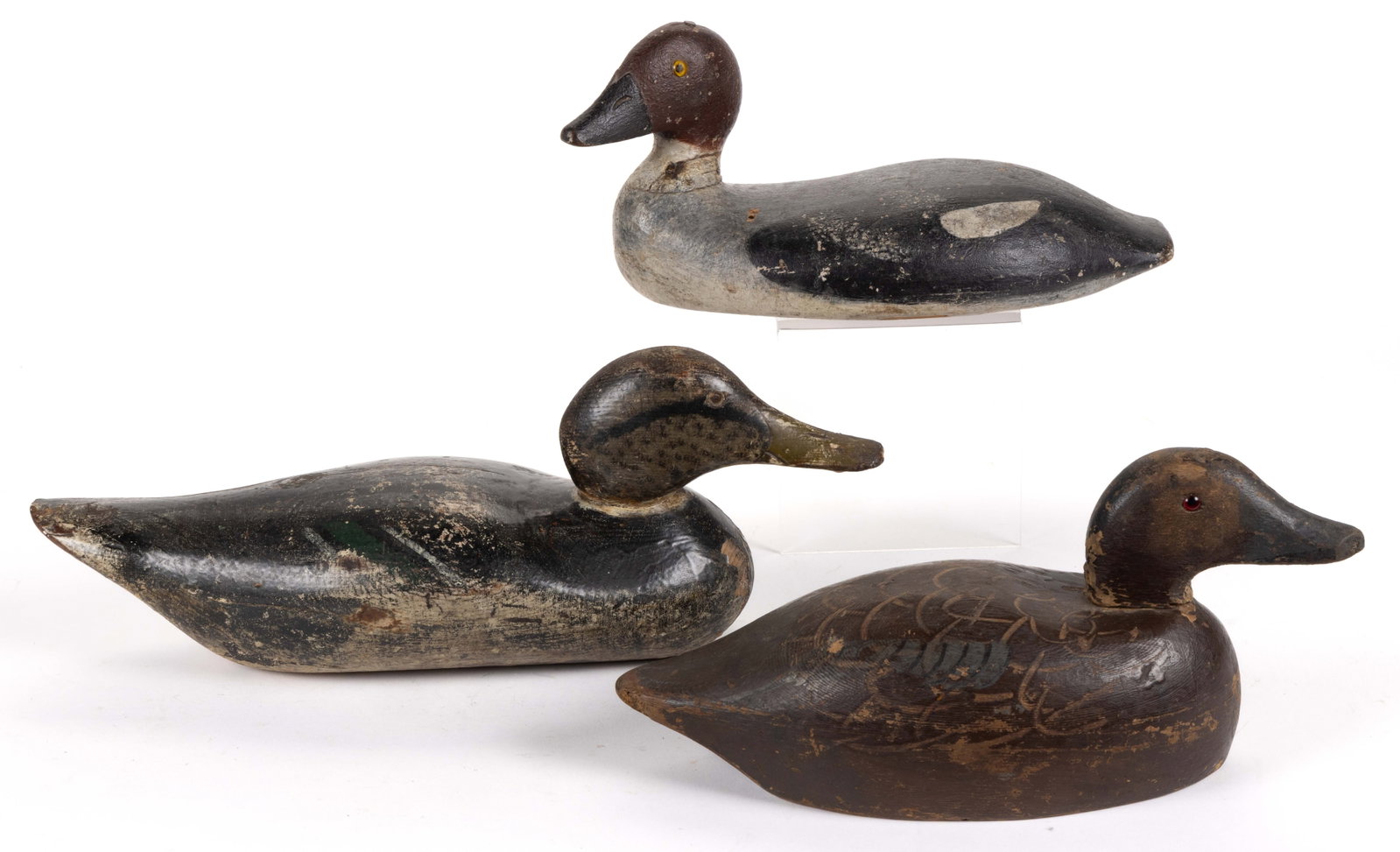 AMERICAN FOLK ART CARVED AND PAINTED DUCK DECOYS, LOT OF THREE: AMERICAN FOLK ART CARVED AND PAINTED DUCK DECOYS, LOT OF THREE, solid body forms with each having glass eyes, each with working surface, one example's underside of base with two circular-form holl