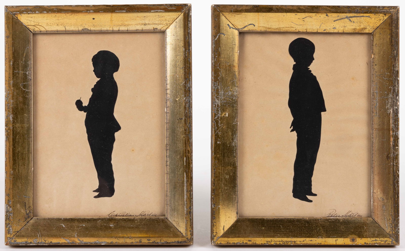 AMERICAN / BRITISH SCHOOL (19TH CENTURY) CUT-AND-PASTED BROTHERS SILHOUETTES, LOT OF TWO: AMERICAN / BRITISH SCHOOL (19TH CENTURY) CUT-AND-PASTED BROTHERS SILHOUETTES, LOT OF TWO, each standing full-figure, one holding an apple, inked "Christian Martin" and "Peter Martin&quo