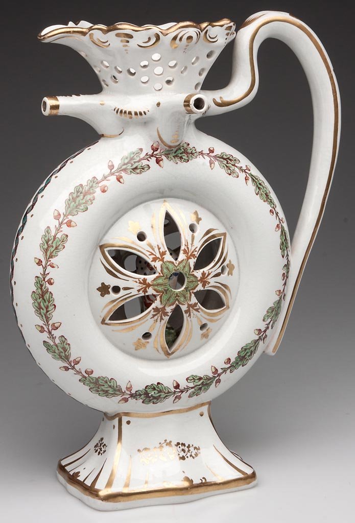 ENGLISH STAFFORDSHIRE DOUBLE PUZZLE JUG: ENGLISH STAFFORDSHIRE DOUBLE PUZZLE JUG, formed as a hollow ring, the center sides cut-out in the pattern of a six-petaled flower, a small figure of a standing acrobat "trapped" to the interior, the r