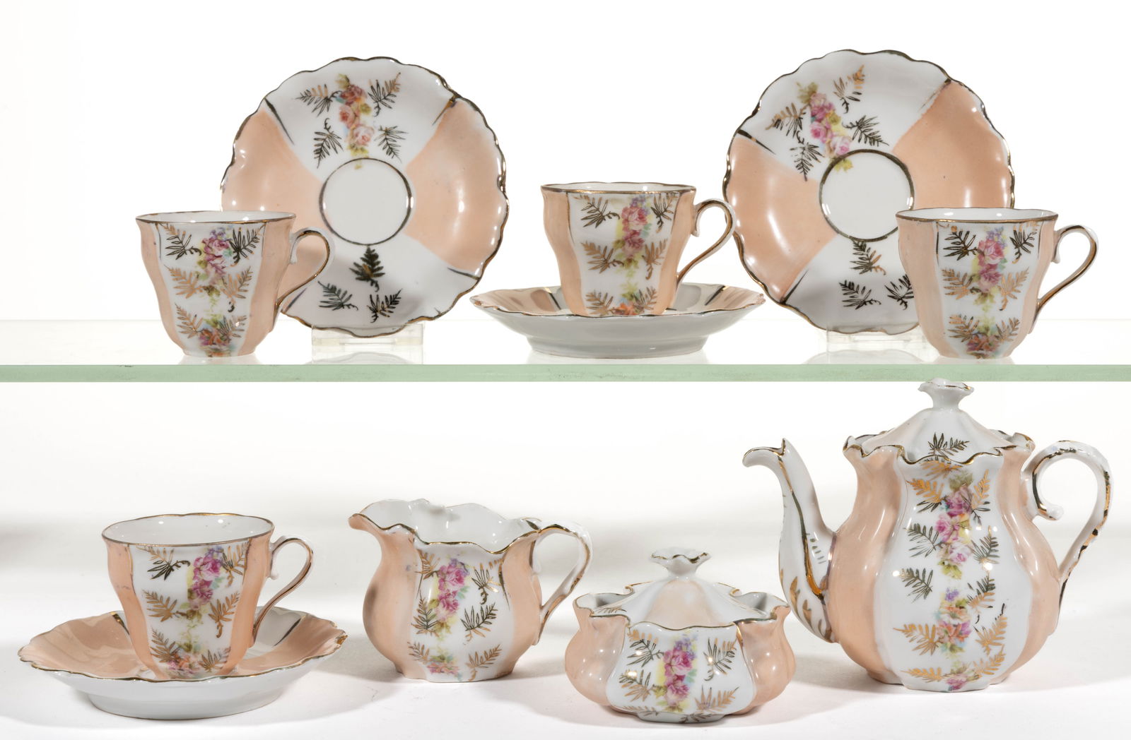 EARLY UNMARKED R.S. PRUSSIA PORCELAIN CHILDREN'S 11-PIECE TEA SET: EARLY UNMARKED R.S. PRUSSIA PORCELAIN CHILDREN'S 11-PIECE TEA SET, ruffled mold form, each having alternating panels of peach and polychrome transfer roses with gilt transfer fern designs, co