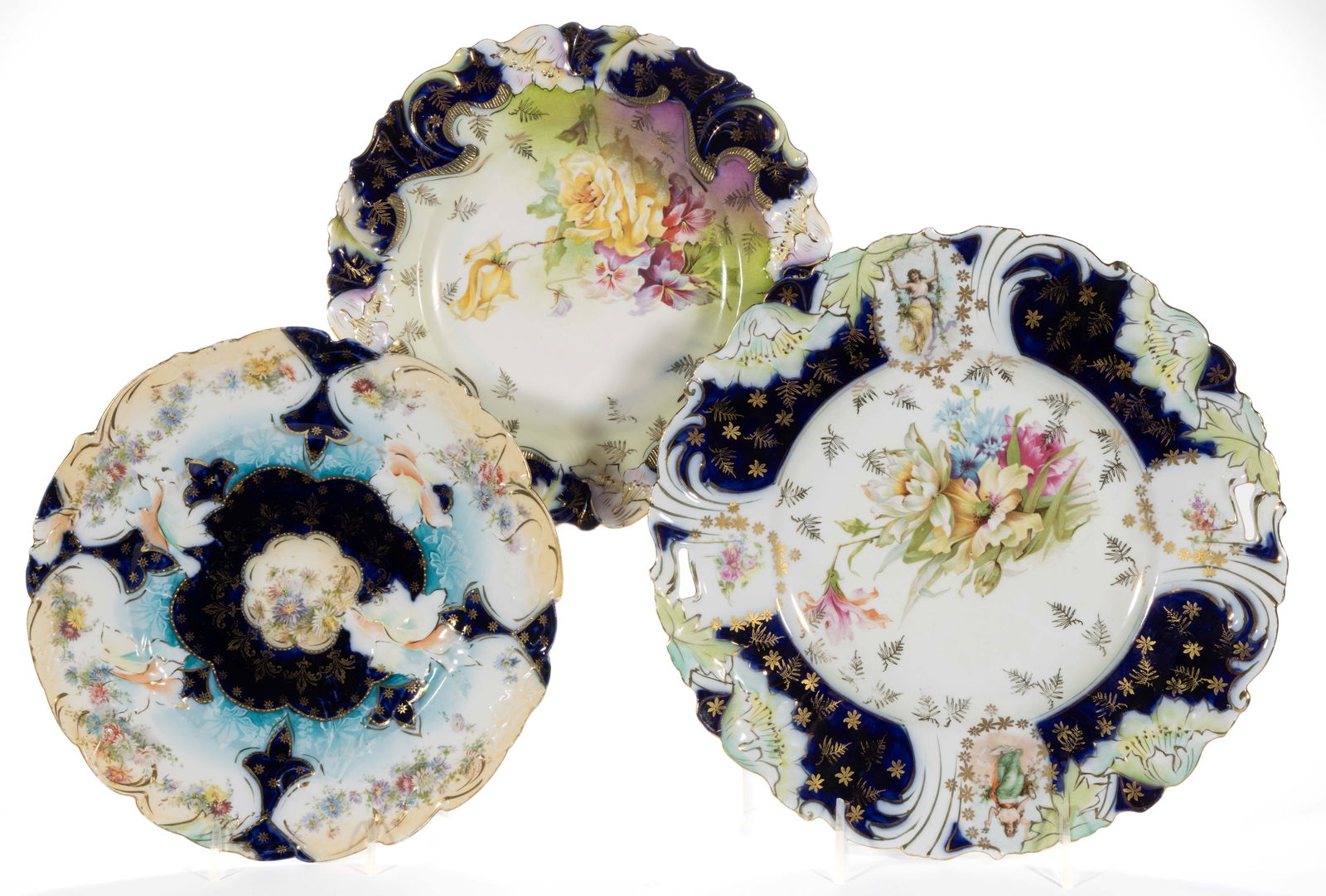 GERMANY SAXE / R.S. PRUSSIA-STYLE COBALT-DECORATED FLORAL MOTIF PLATES, LOT OF THREE: GERMANY SAXE / R.S. PRUSSIA-STYLE COBALT-DECORATED FLORAL MOTIF PLATES, LOT OF THREE, comprising a Mold RS 31 plate with buff-colored rim featuring assorted flower decorations and two RS Steeple Mold