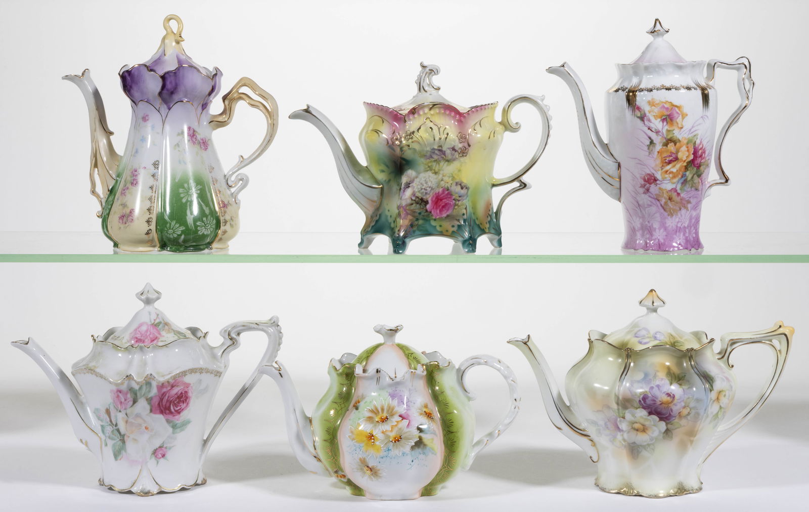 R.S. PRUSSIA PORCELAIN FLORAL MOTIF TEAPOTS, LOT OF SIX: R.S. PRUSSIA PORCELAIN FLORAL MOTIF TEAPOTS, LOT OF SIX, including one six-footed RSP Mold 642 featuring assorted flowers on yellow and green ground with pink accents, one RSP Mold 502 example ha
