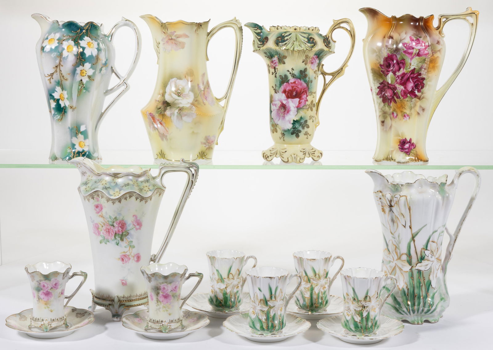 R.S. PRUSSIA PORCELAIN FLORAL MOTIF CHOCOLATE ARTICLES, LOT OF 18: R.S. PRUSSIA PORCELAIN FLORAL MOTIF CHOCOLATE ARTICLES, LOT OF 18, comprising a RSP Mold 703 pot with four cup and saucer sets featuring white daffodils accented in gilt with green leaves, a