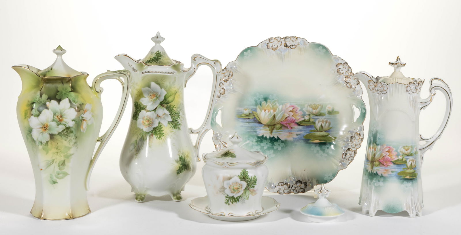 R.S. PRUSSIA PORCELAIN FLORAL MOTIF ARTICLES, LOT OF SIX: R.S. PRUSSIA PORCELAIN FLORAL MOTIF ARTICLES, LOT OF SIX, comprising two examples featuring dogwood and pine transfer including a four-footed chocolate pot and a satin finish covered jar with underpla