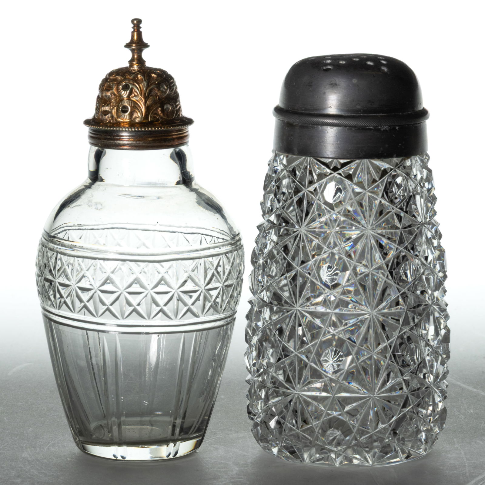 MT. WASHINGTON AND ENGLISH CUT GLASS SUGAR SHAKERS, LOT OF TWO: MT. WASHINGTON AND ENGLISH CUT GLASS SUGAR SHAKERS, LOT OF TWO, colorless, comprising a Mt. Washington/Pairpoint "Russian" example with original two-part lid, and an English Star Band ovoid