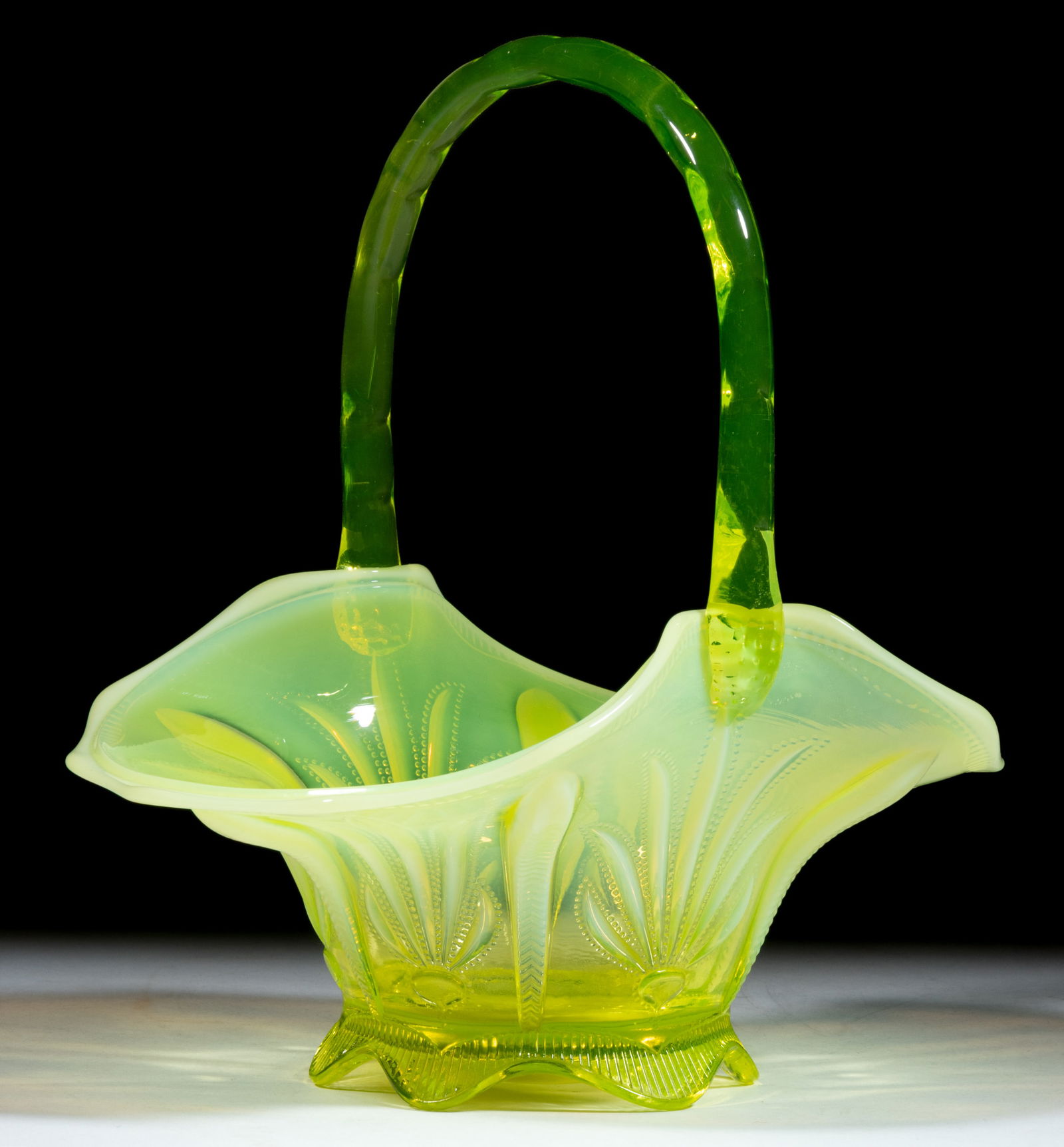 FENTON CACTUS BASKET: FENTON CACTUS BASKET, Vaseline/topaz opalescent (reacts under black light), with applied handle. Fenton Art Glass Co. Circa 1959. 11" HOA. Provenance: From the collection of the late
