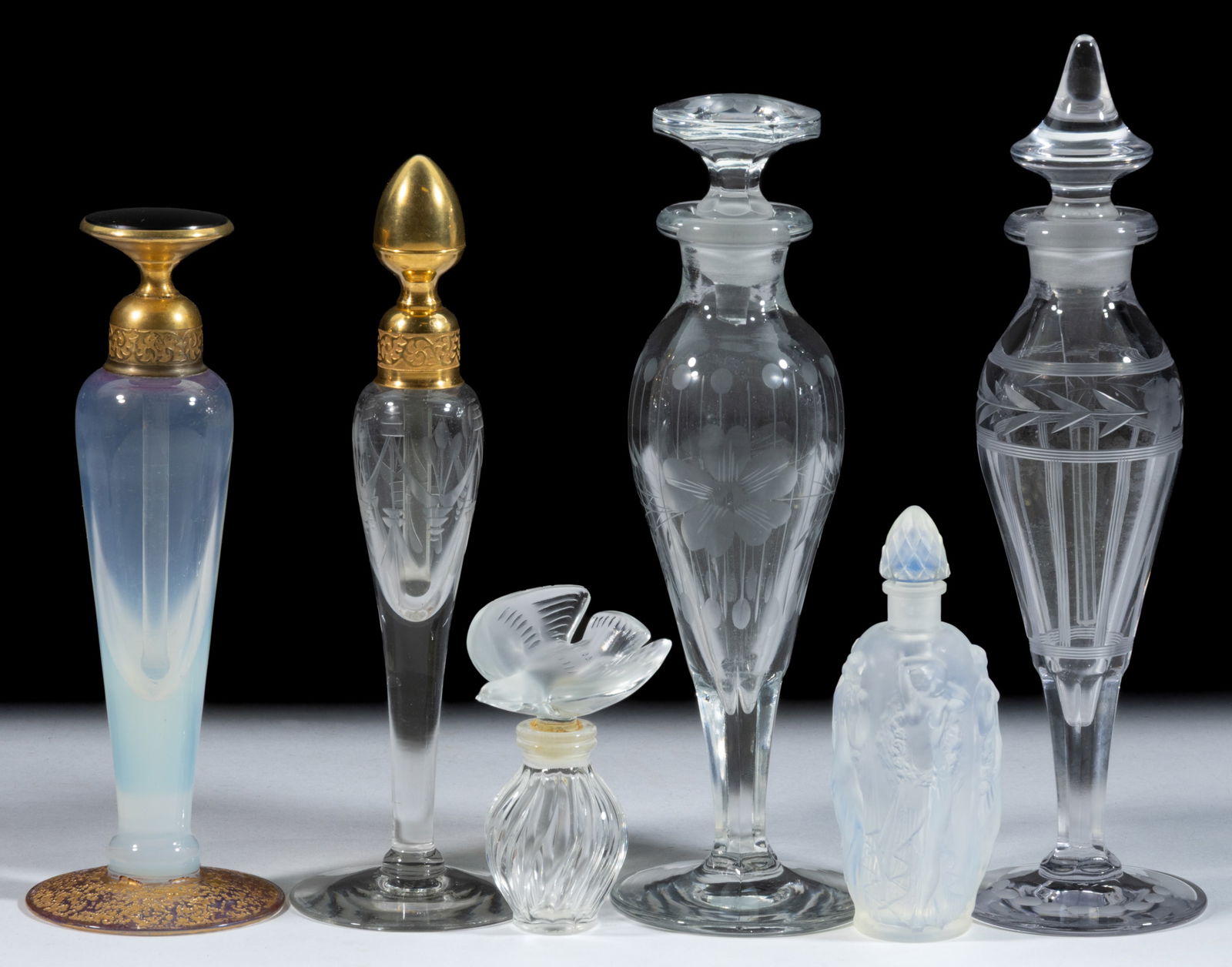 ASSORTED GLASS PERFUME BOTTLES, LOT OF SIX: ASSORTED GLASS PERFUME BOTTLES, LOT OF SIX, colorless, comprising an opalescent example with female figures, signed "Sabino / Paris"; a small signed Lalique Nina Ricci; an opalescent si