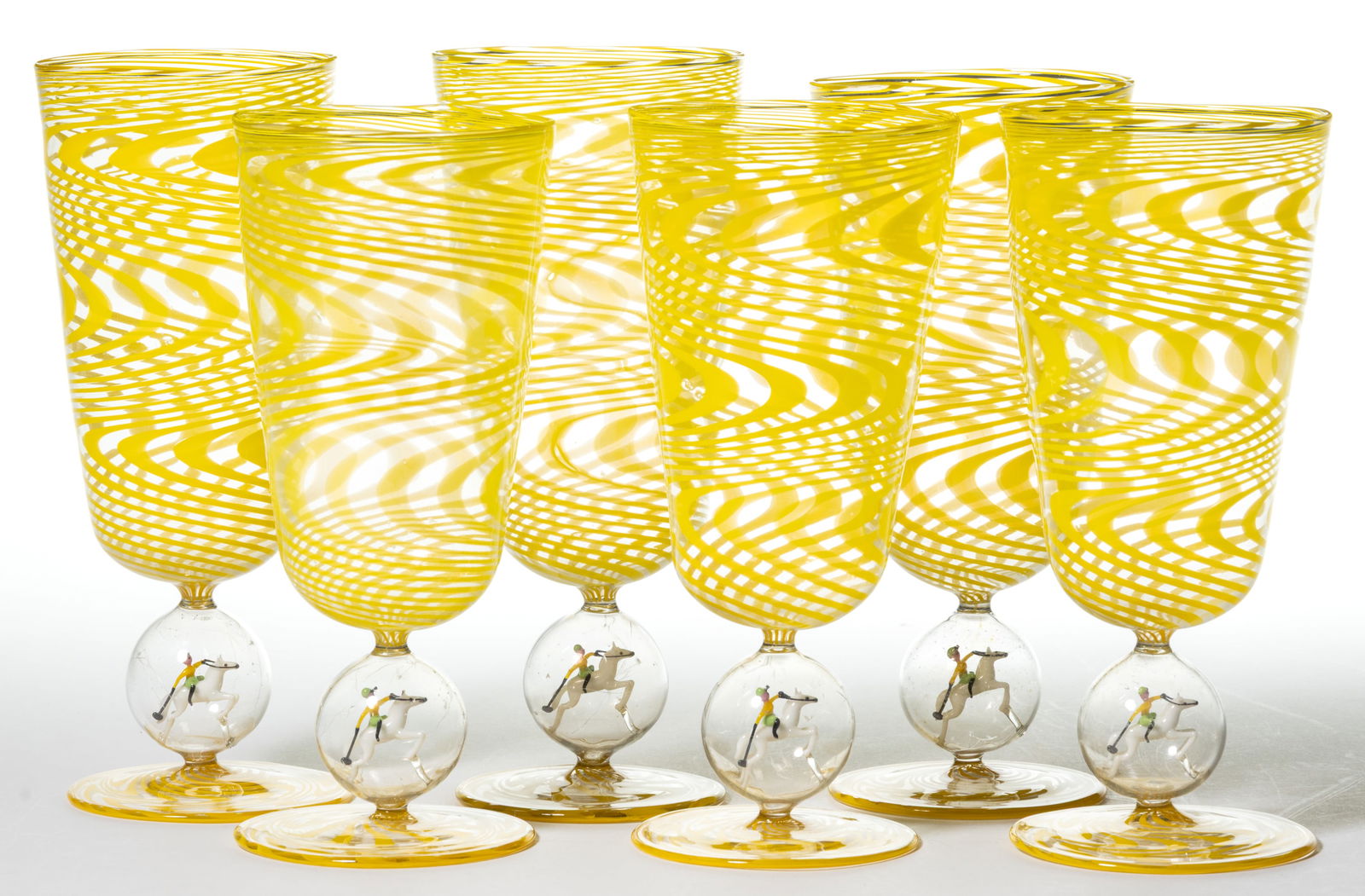 GERMAN ART GLASS BIMINI-TYPE POLO MATCH ALE / COCKTAIL GLASSES, SET OF SIX: GERMAN ART GLASS BIMINI-TYPE POLO MATCH ALE / COCKTAIL GLASSES, SET OF SIX, bright yellow swirl on colorless, each having a lampwork figure holding a mallet and riding a horse in the stem. F